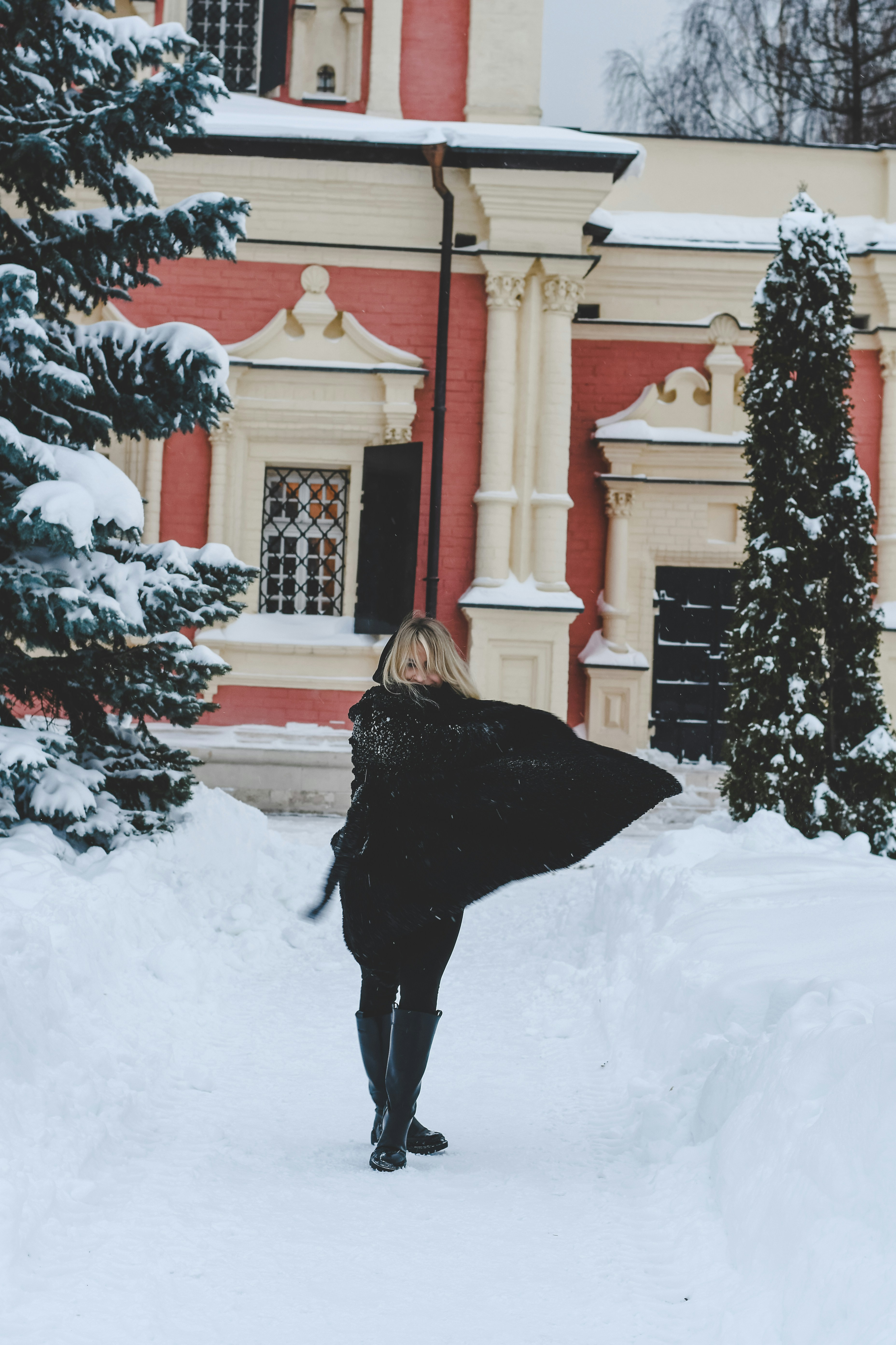Woman in black coat walking in snowy path