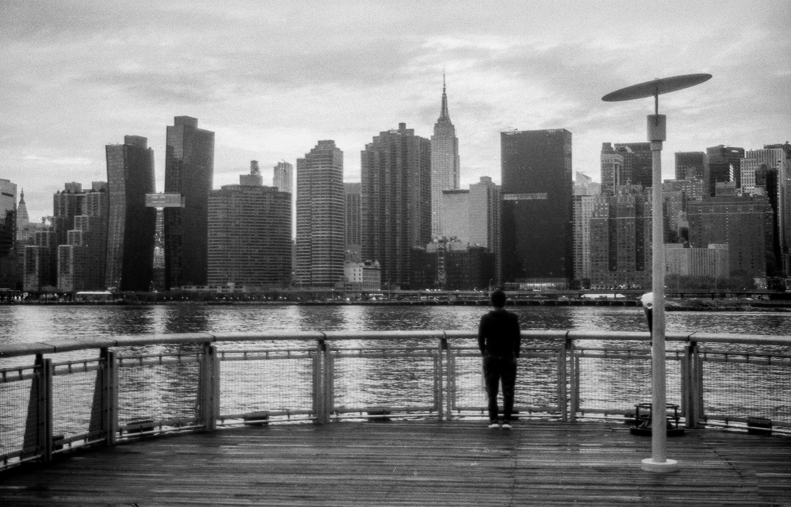 Man looking at city skyline across water