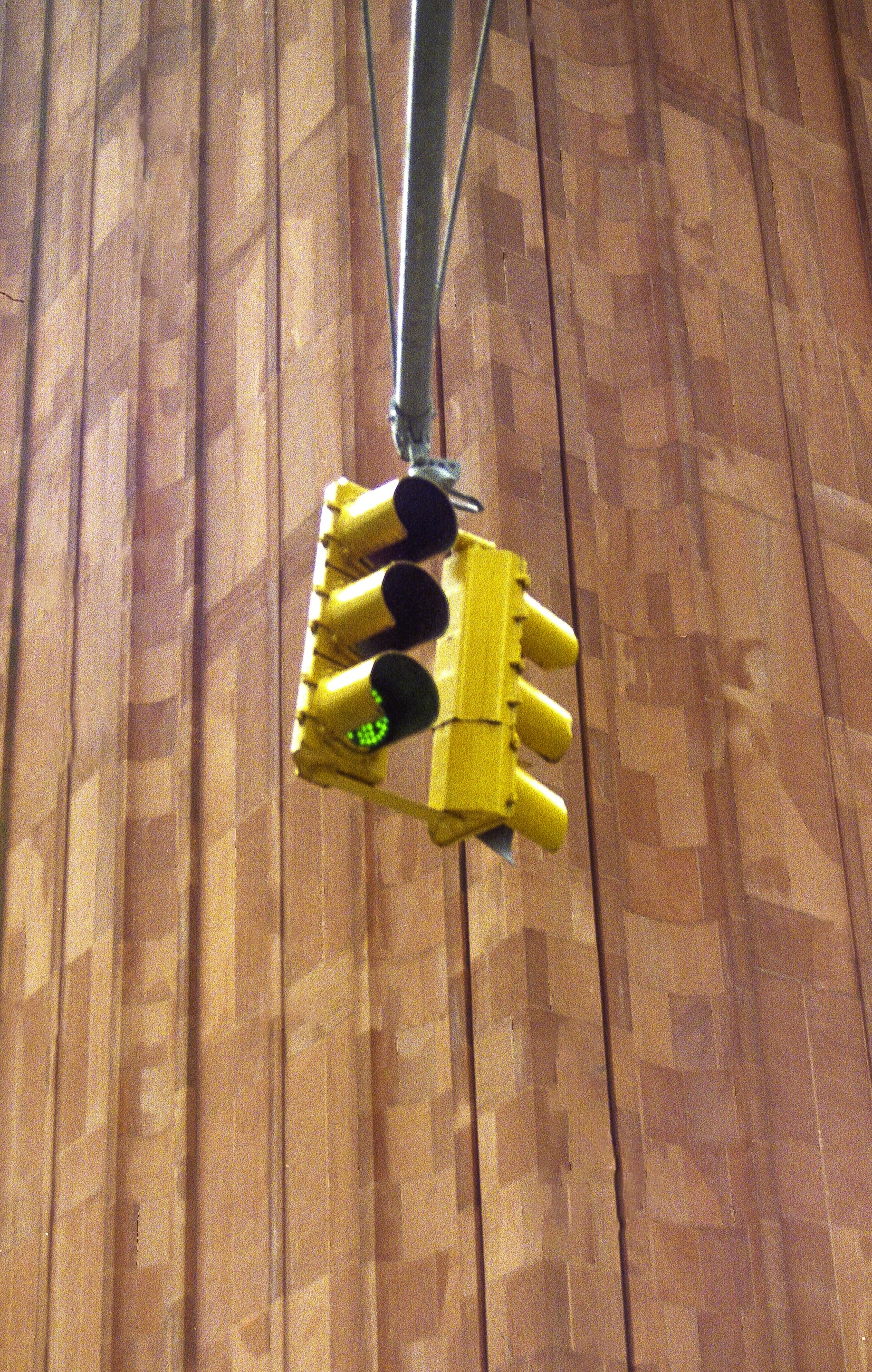 A yellow traffic light with a green light illuminated.