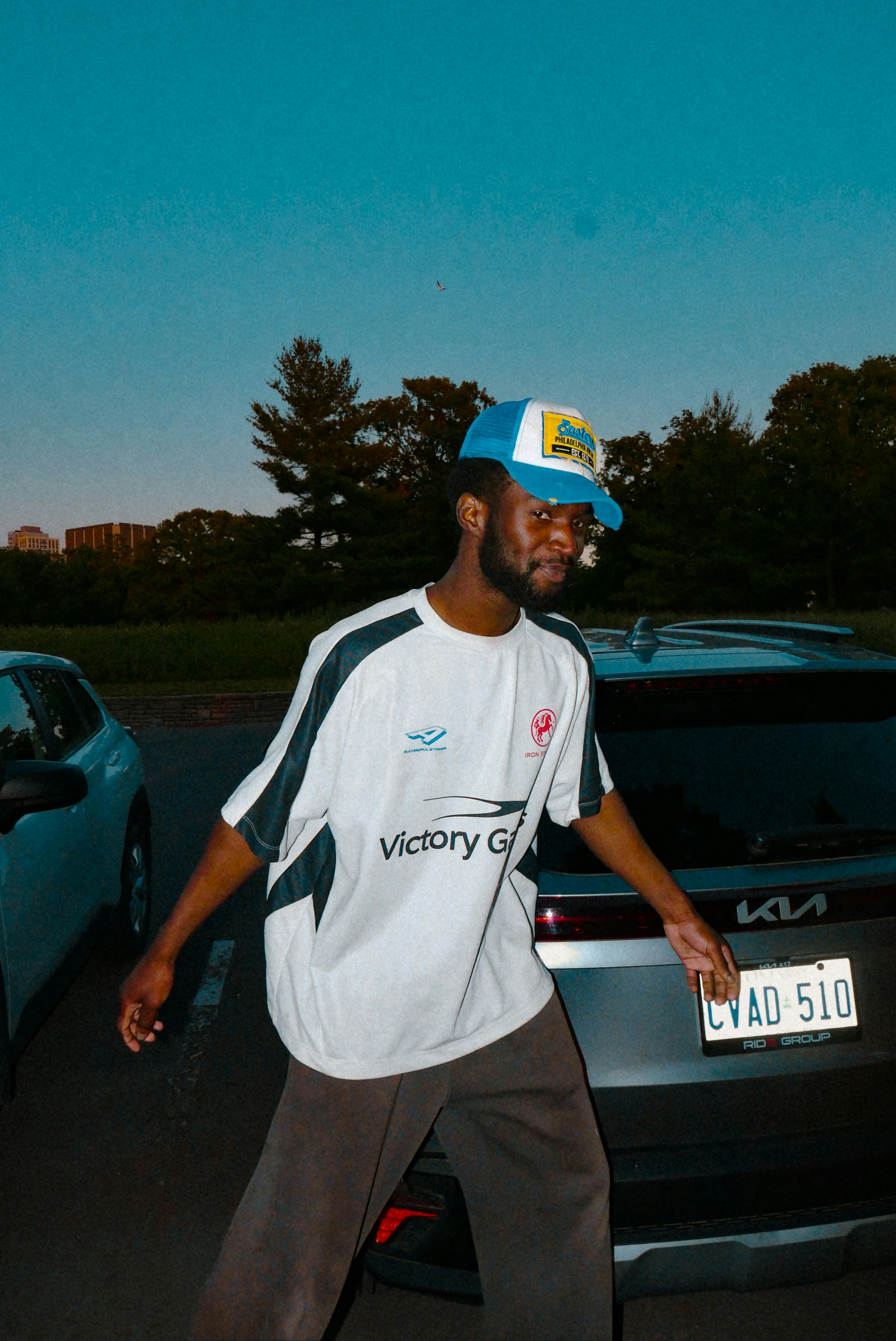 Man wearing a hat and jersey in a parking lot