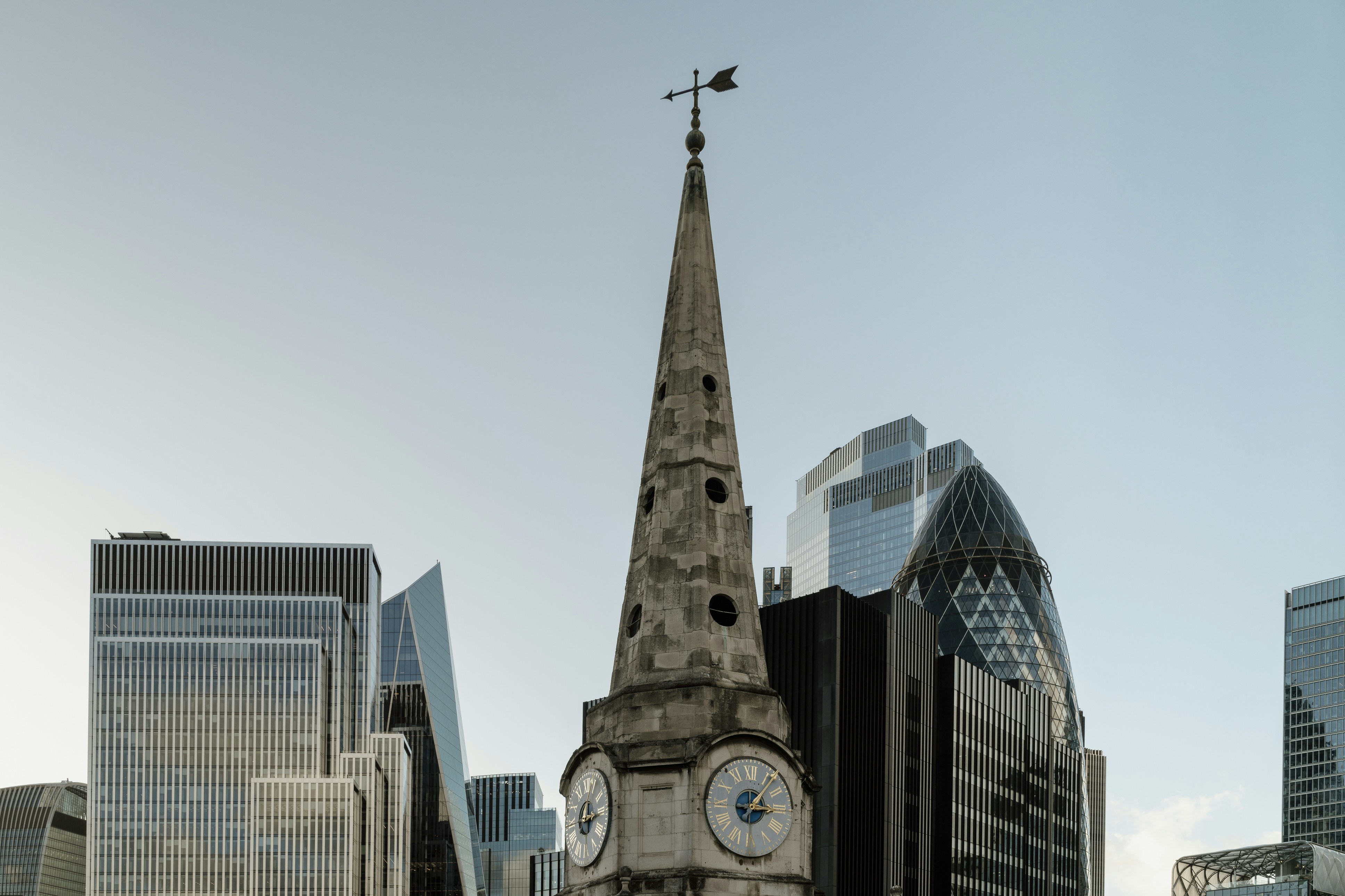 Historic church spire amidst modern city skyscrapers