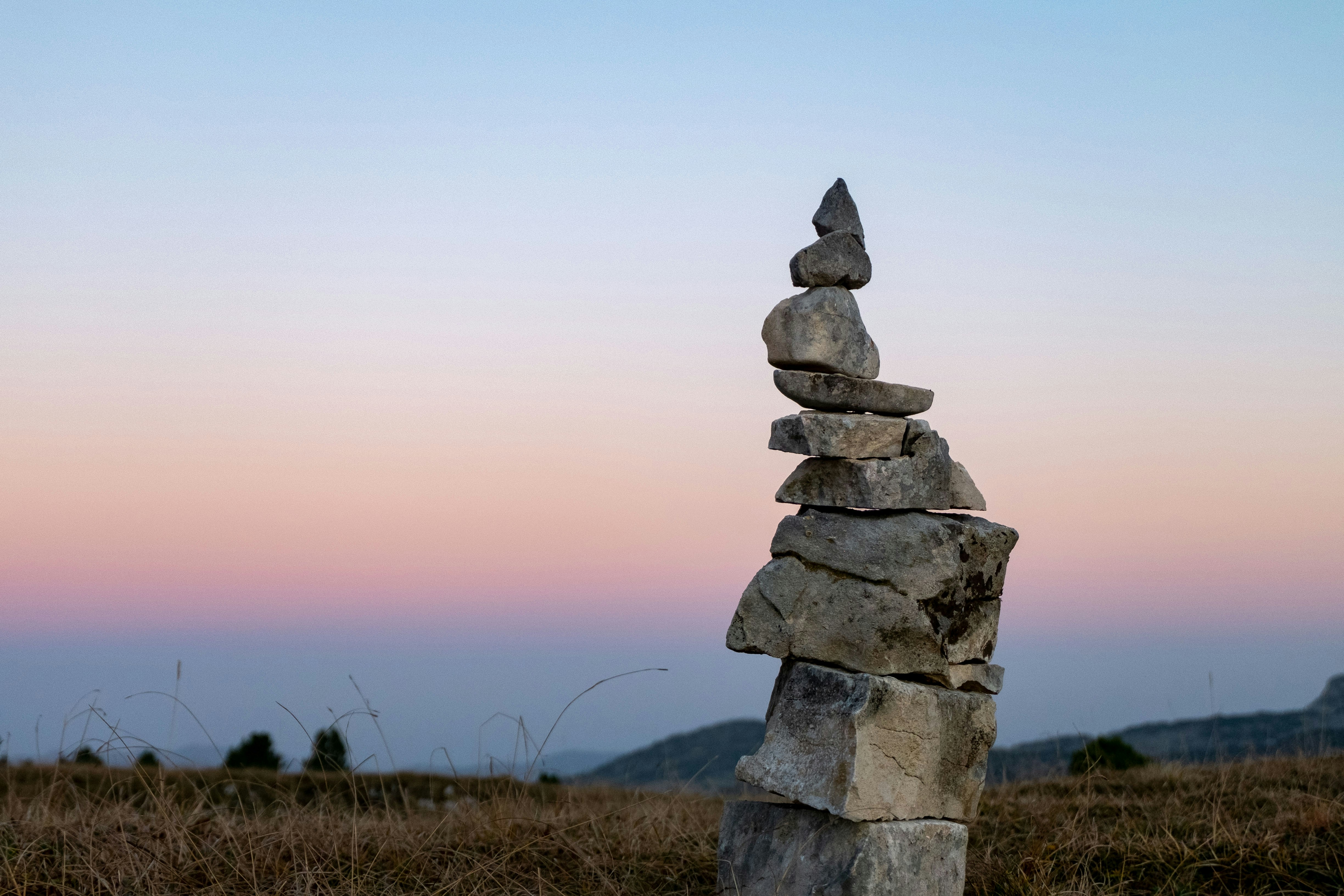 Stack of stones in a field at sunset