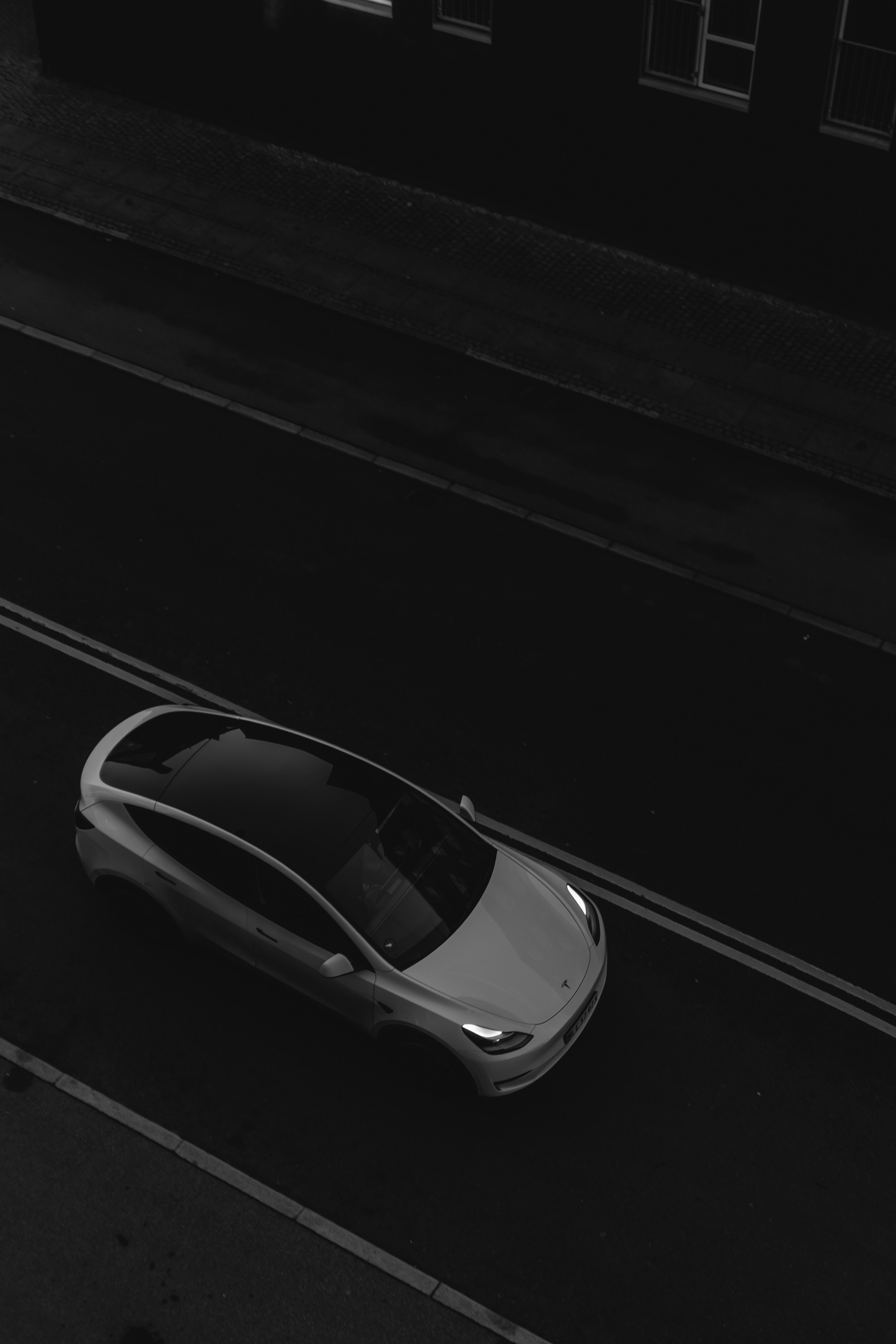 A white car driving on a dark road at night.