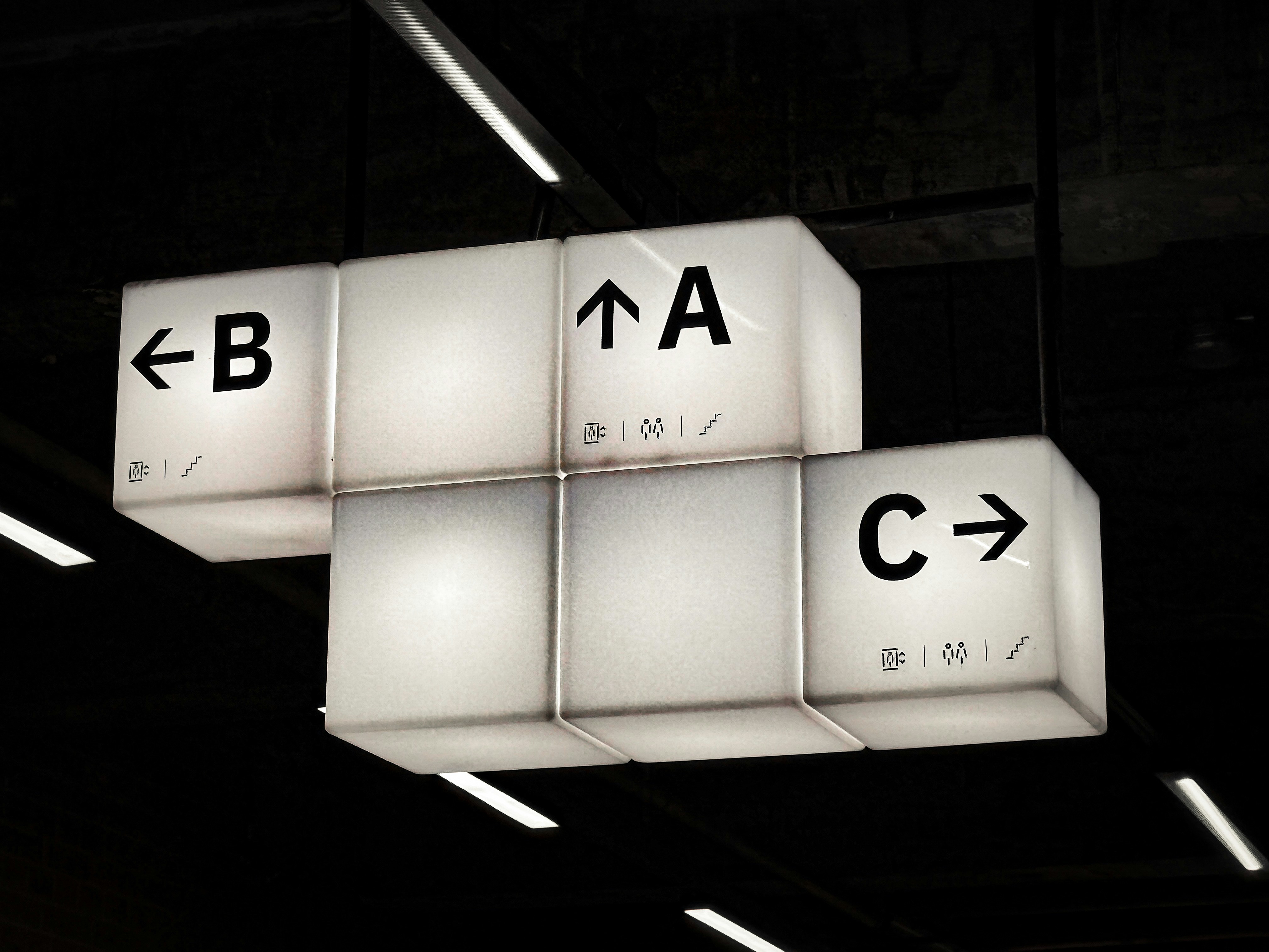 Illuminated directional signs point to a, b, and c.