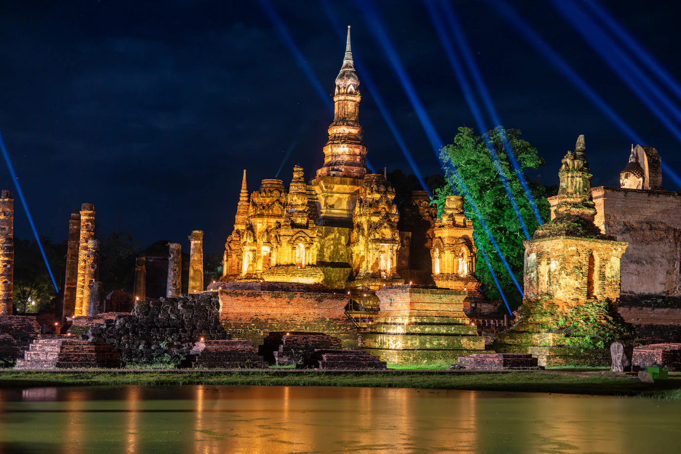 Illuminated ancient temple reflected at Sukhothai Historical Park, Thailand