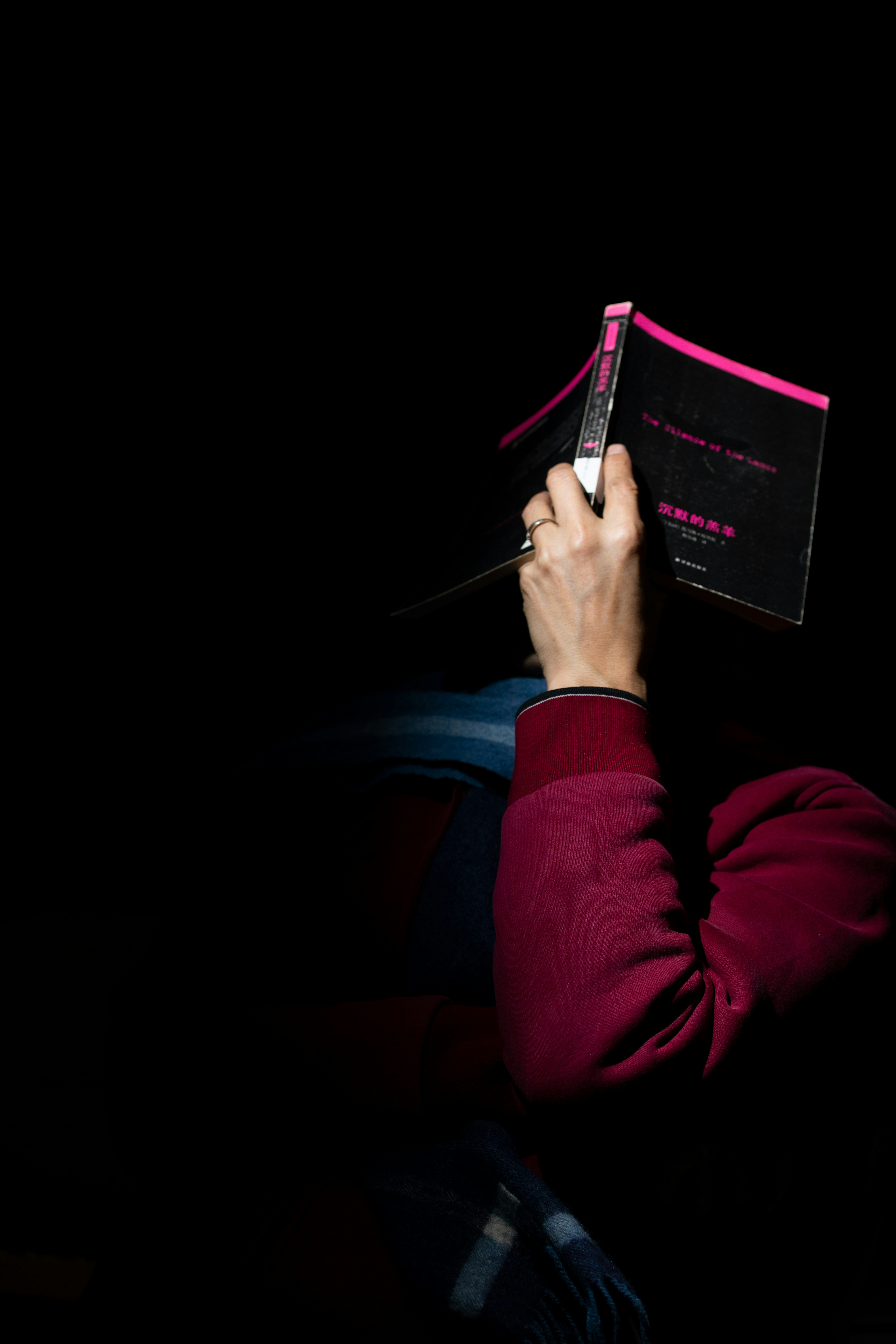 Person reading a book in the dark