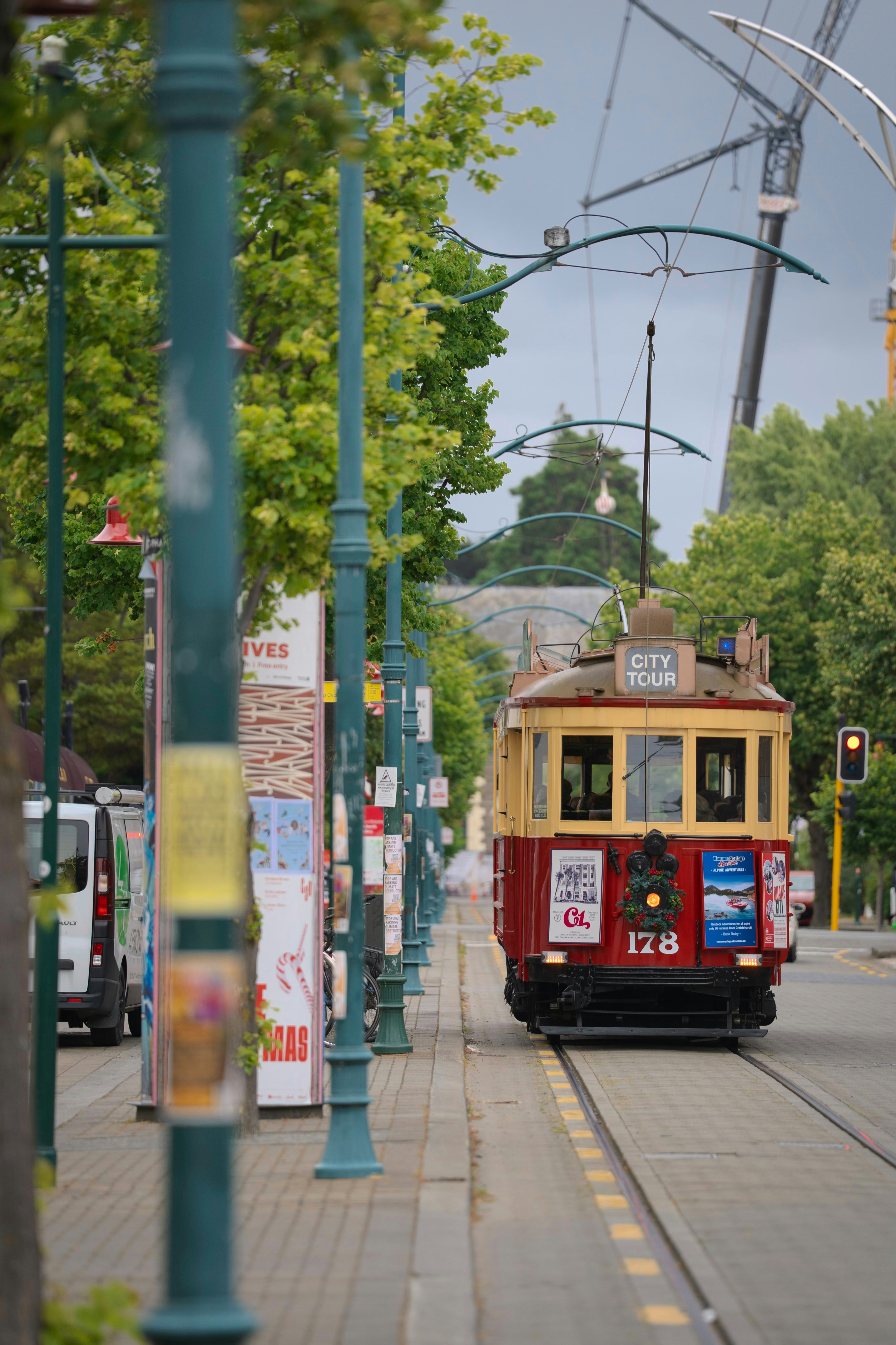 A vintage tram with "city tour" sign drives on tracks.