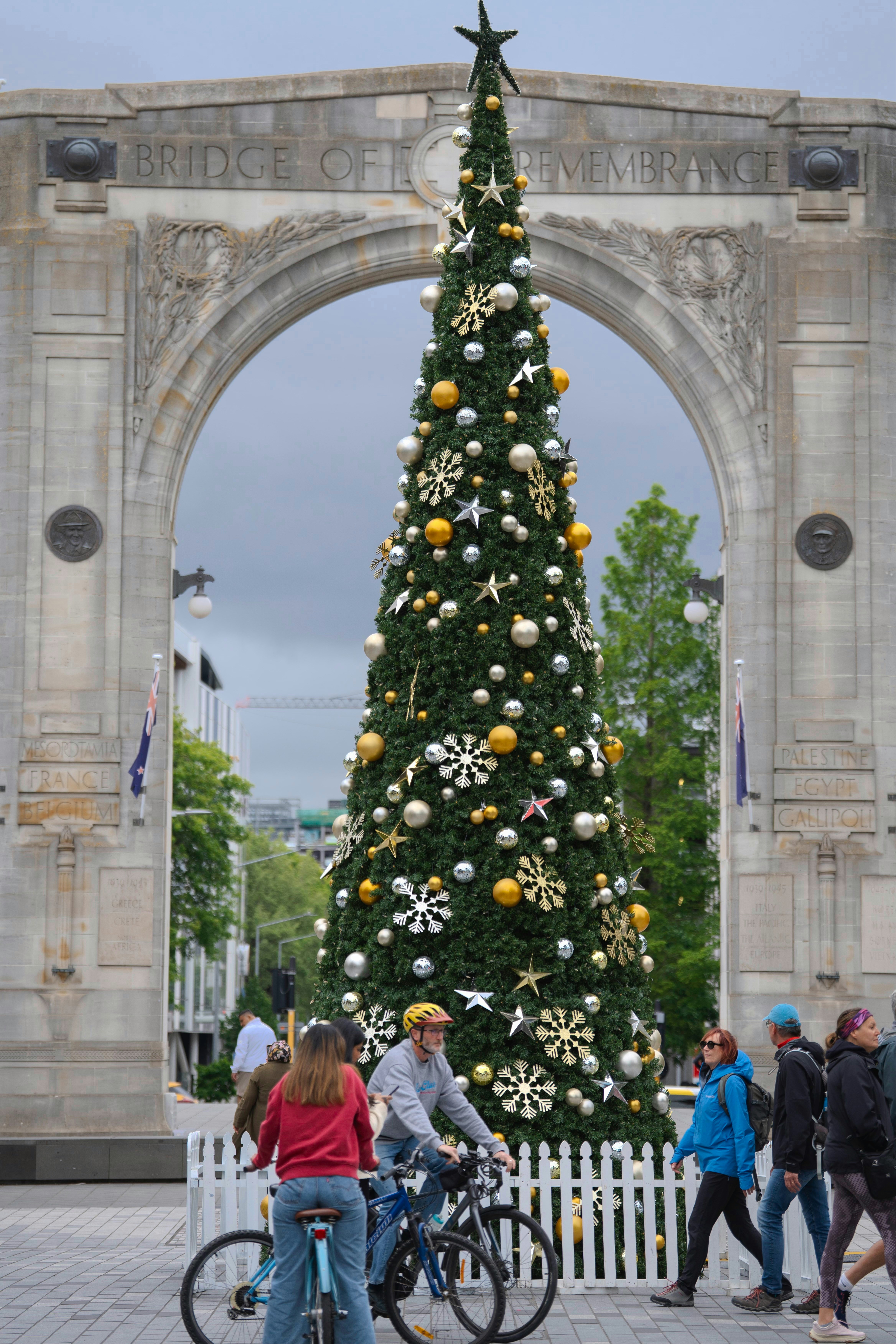 Decorated christmas tree under an archway with people