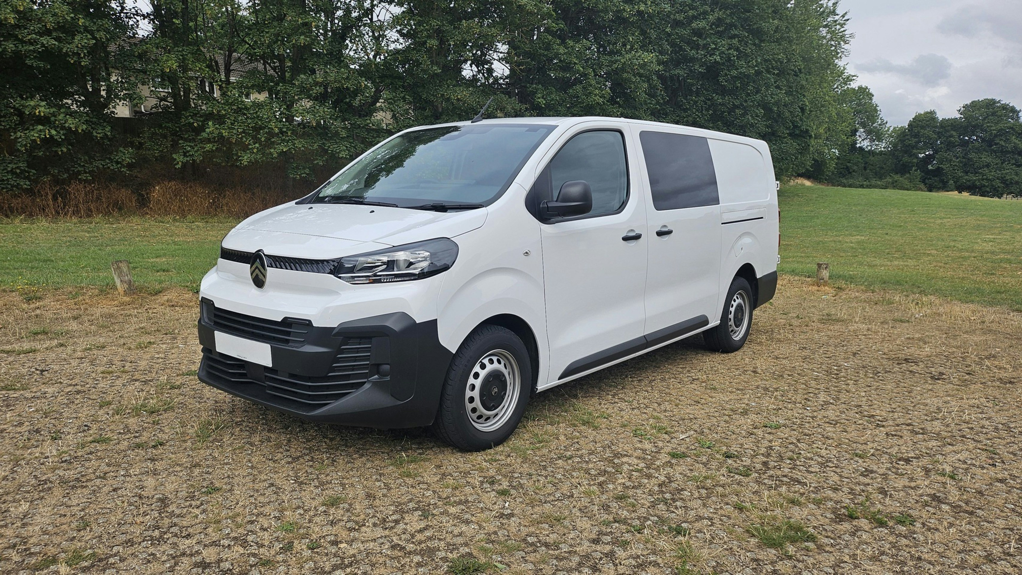 A white cargo van parked on gravel outdoors.