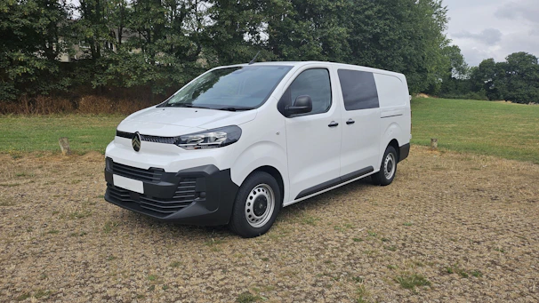 A white cargo van parked on gravel outdoors.