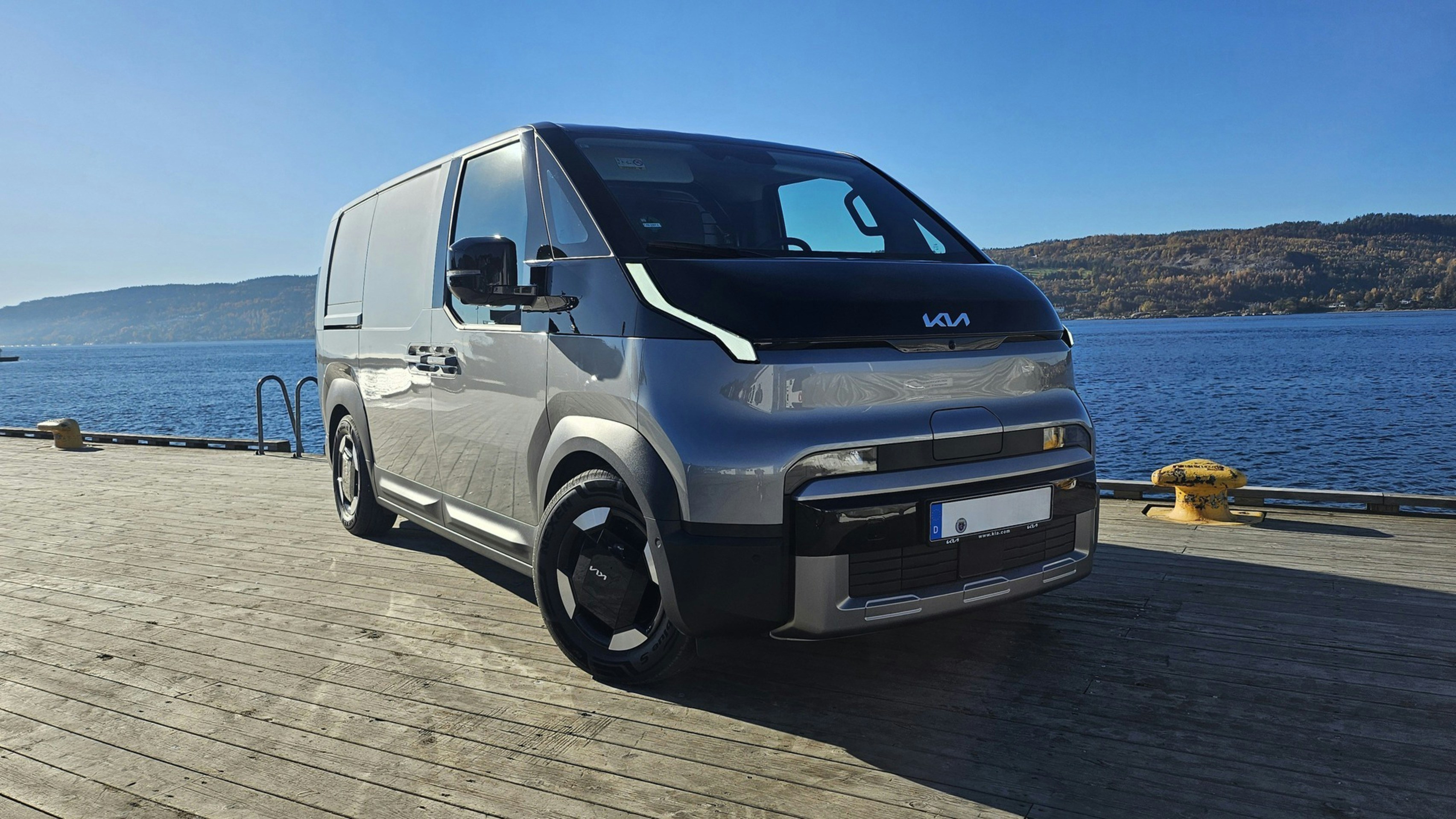 Silver electric van parked by the water