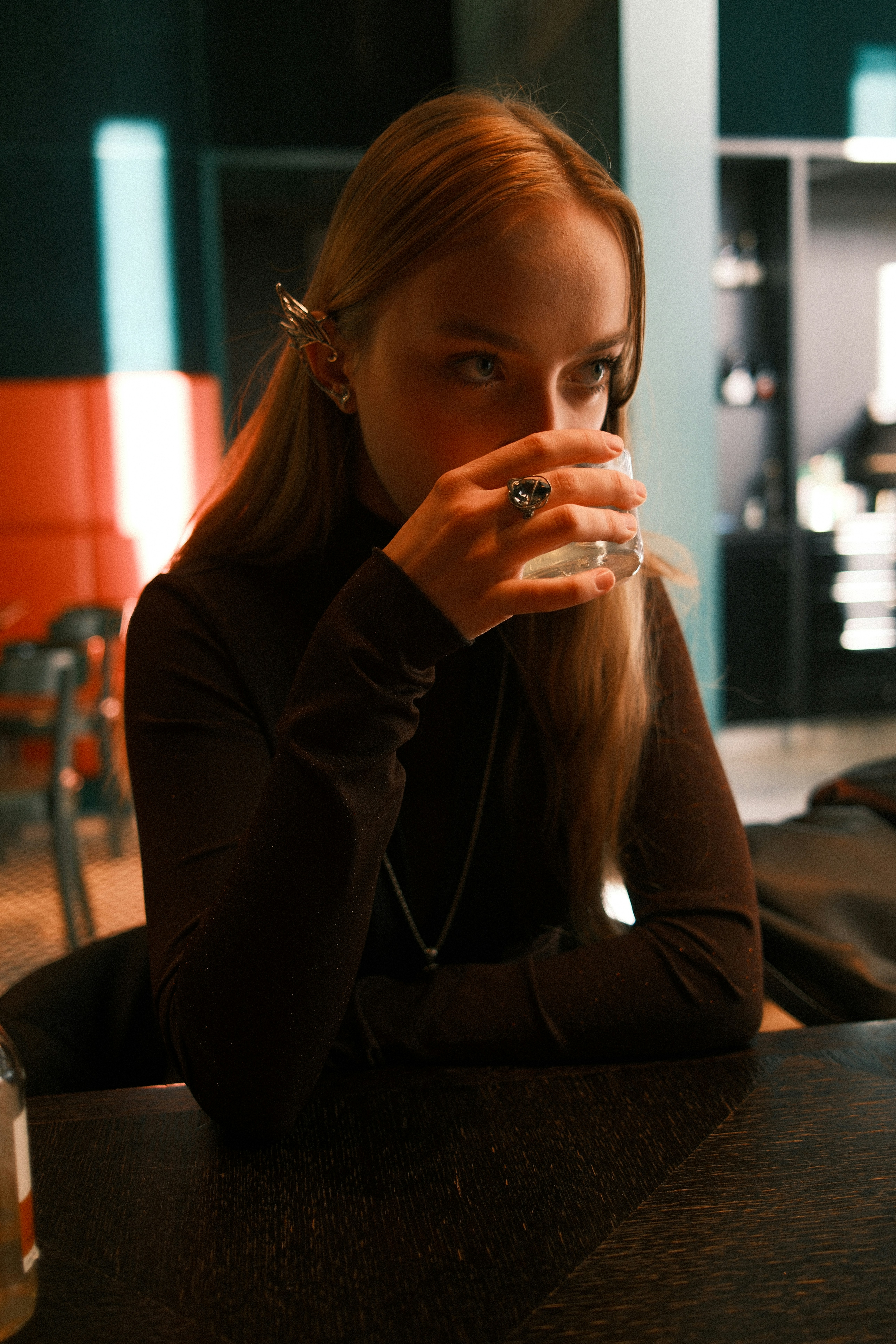 Jeune femme boit dans un verre à une table