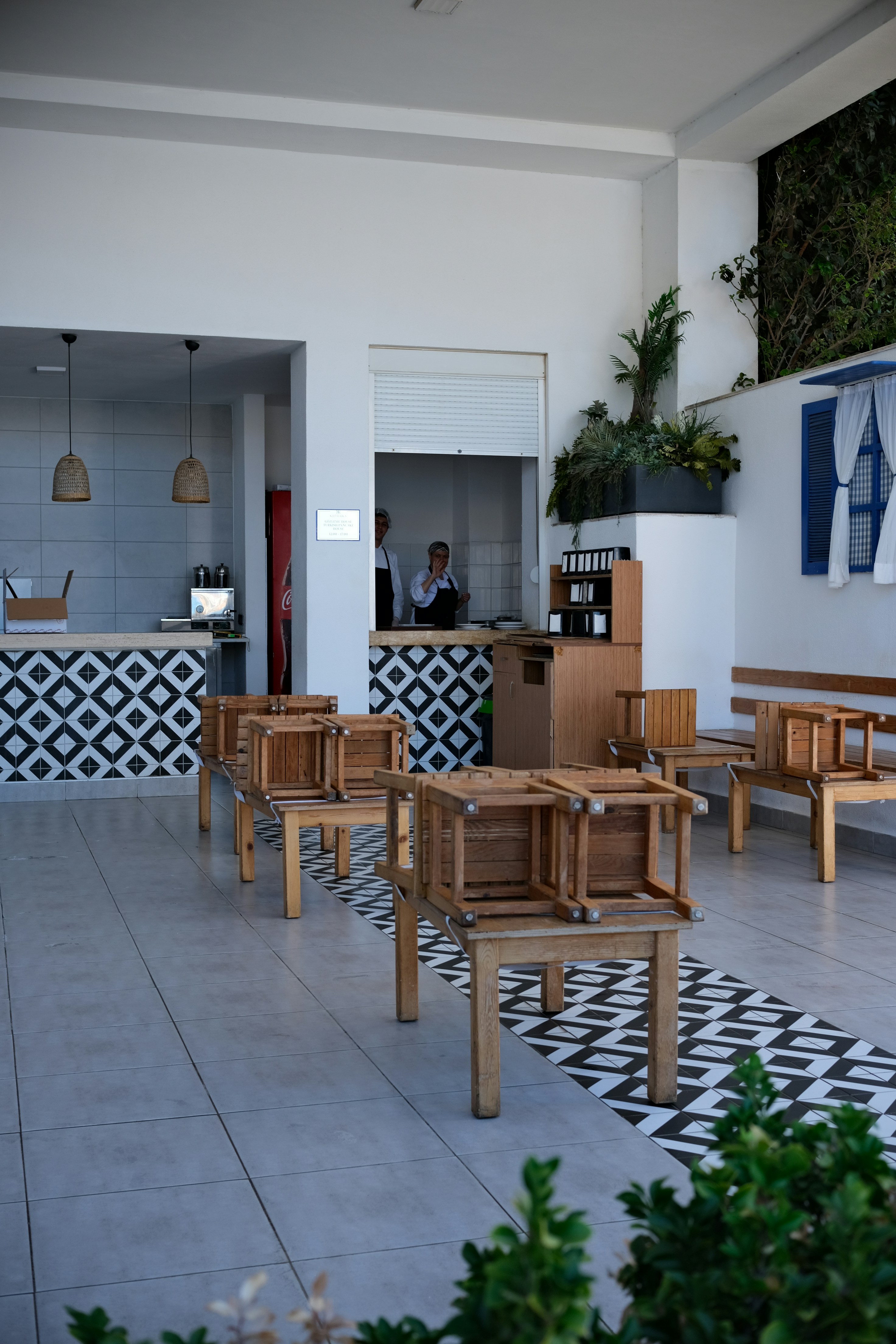 Empty cafe with wooden chairs and tables stacked tables.