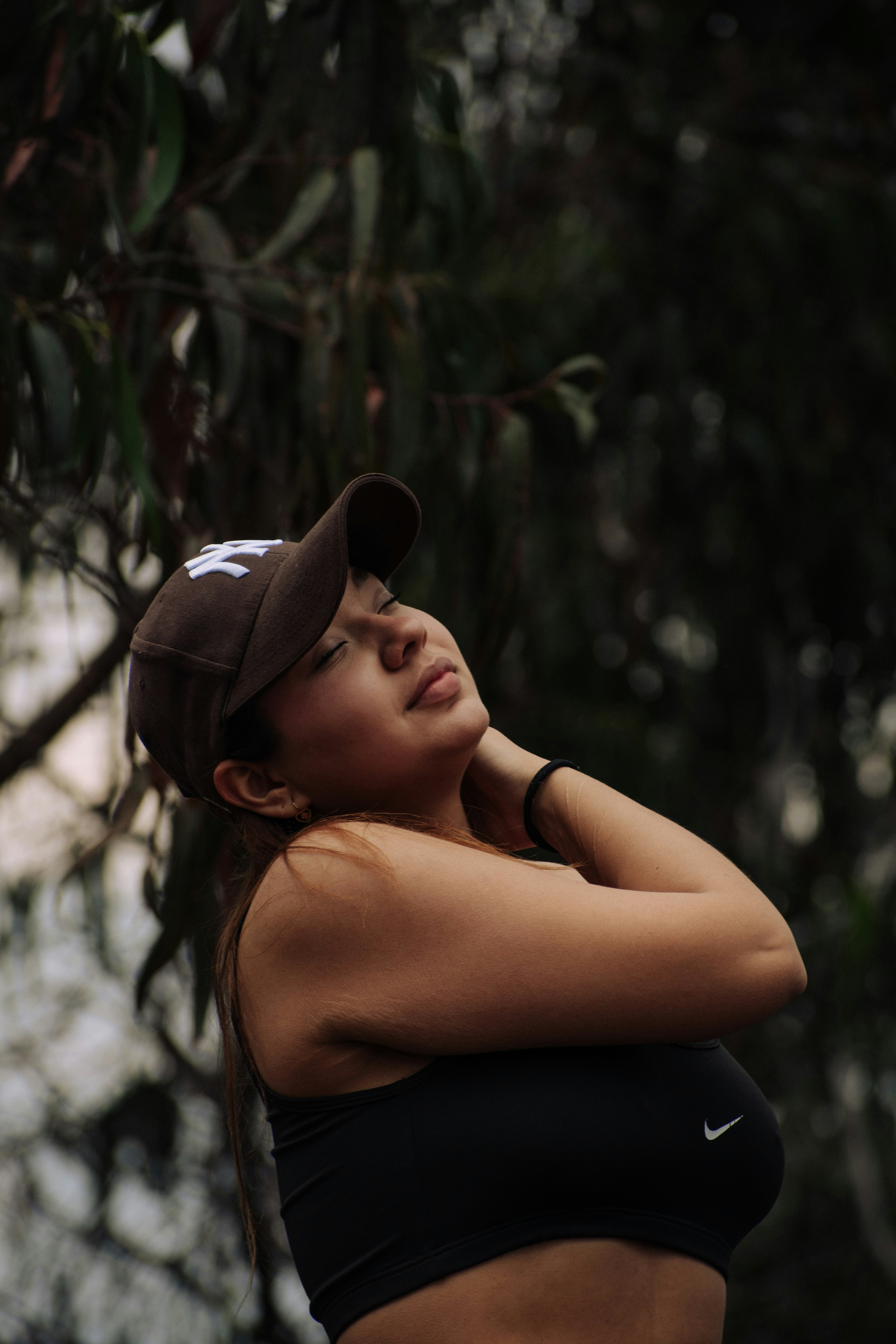 A woman in a baseball cap and sports bra