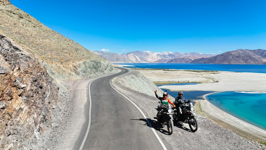 Two motorcycles parked by a mountain lake in Ladakh