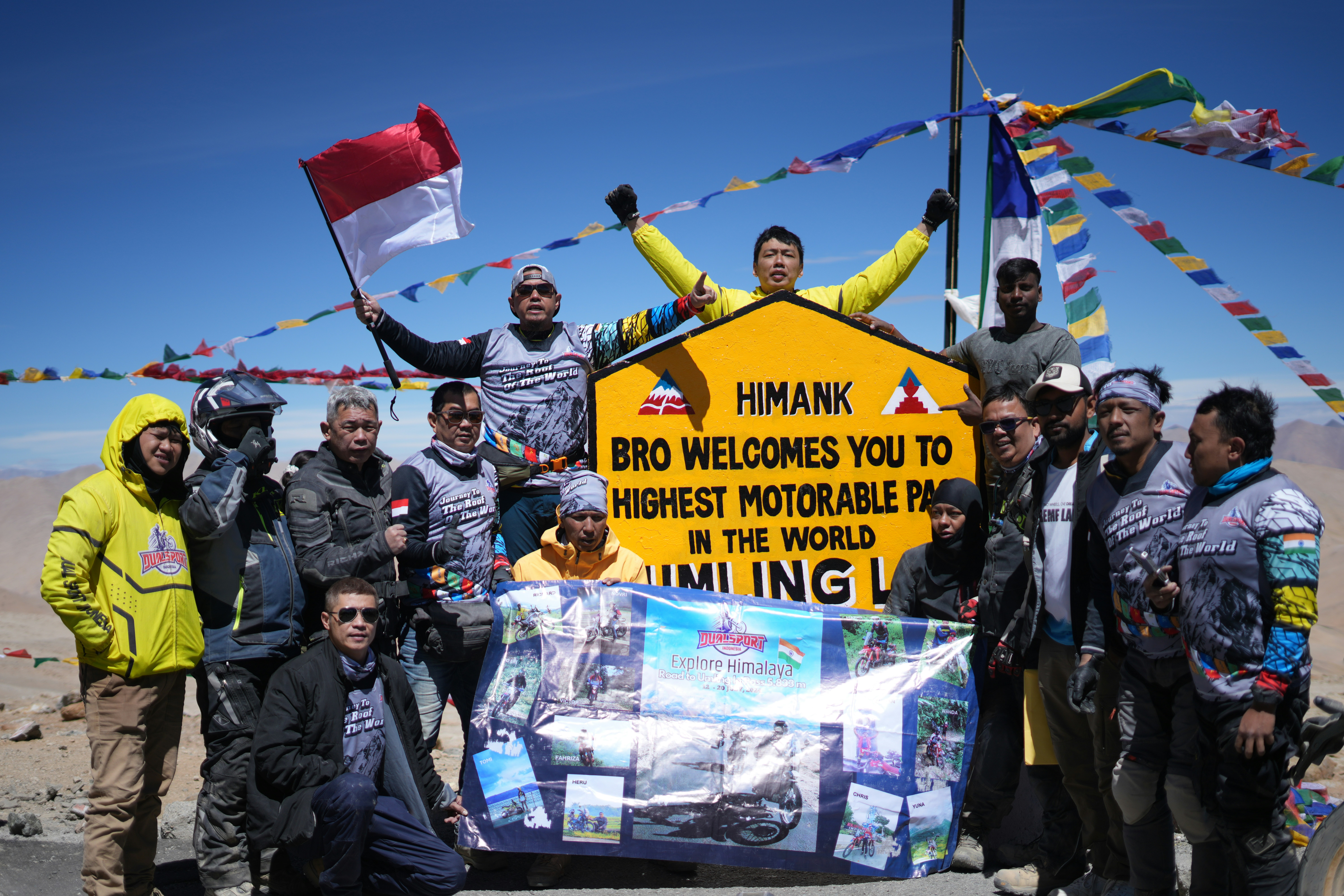 Group poses at highest motorable pass sign