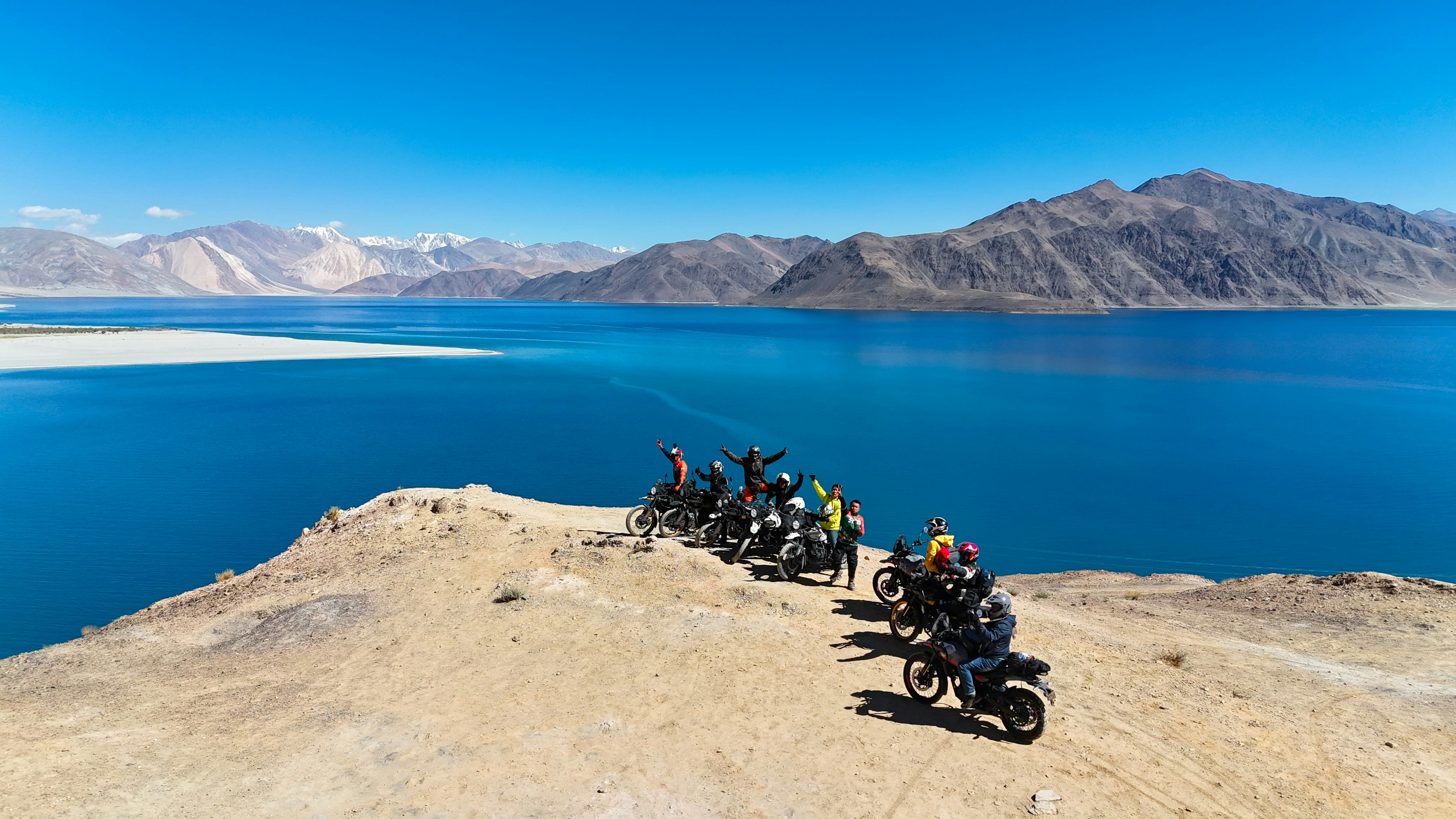 Group of motorcyclists on a scenic mountain lake overlook.