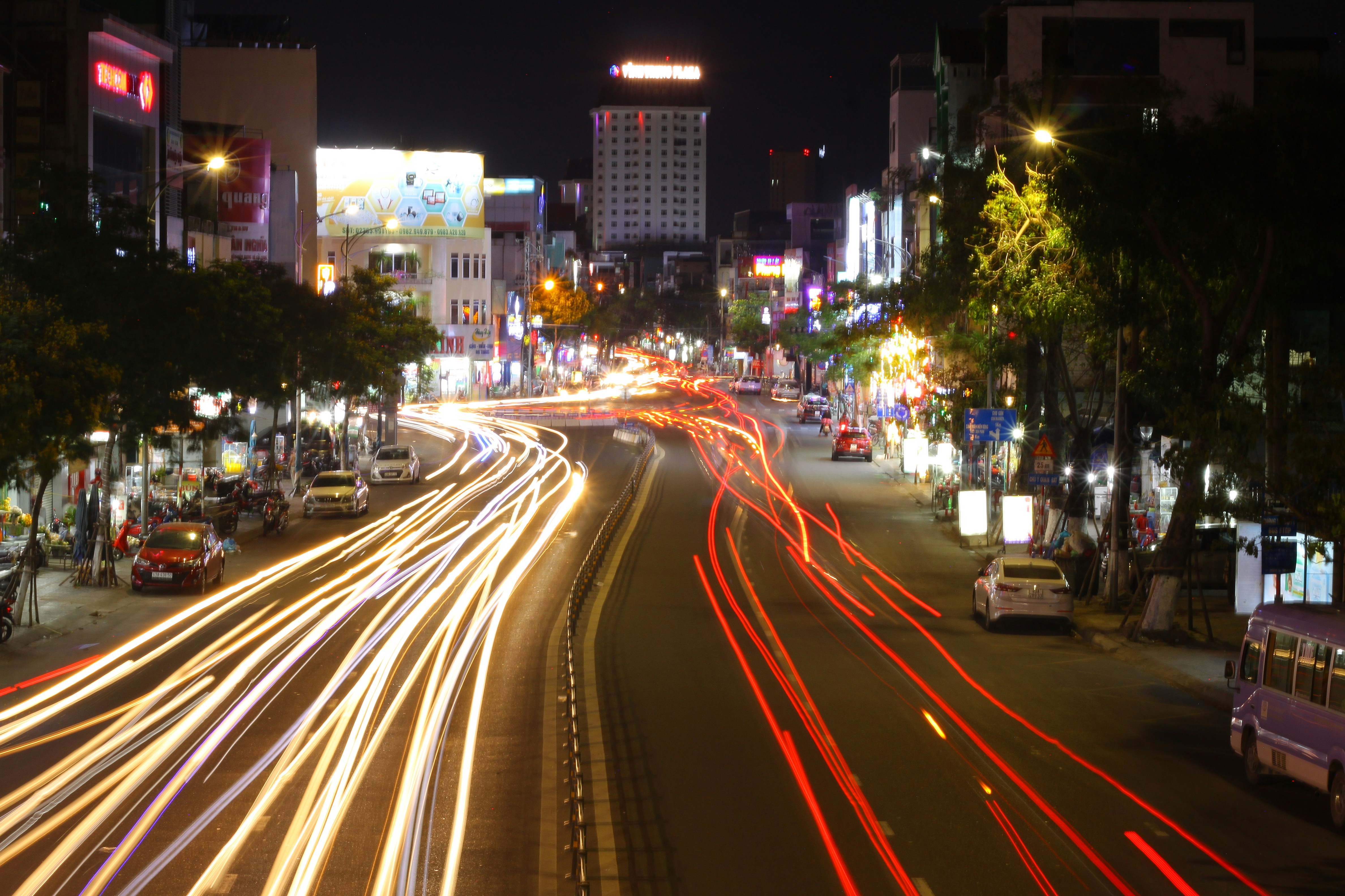 City street at night with light trails from cars.