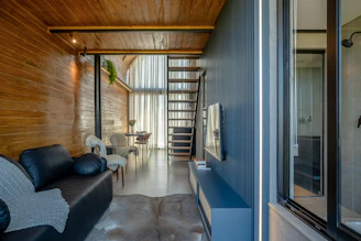 Modern living room with wooden walls and stairs
