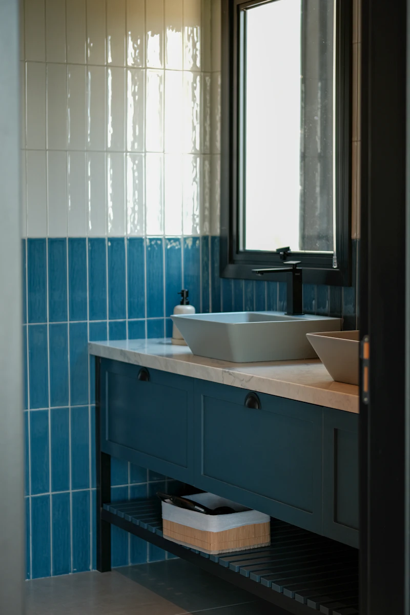 Modern bathroom vanity with blue tile and vessel sinks