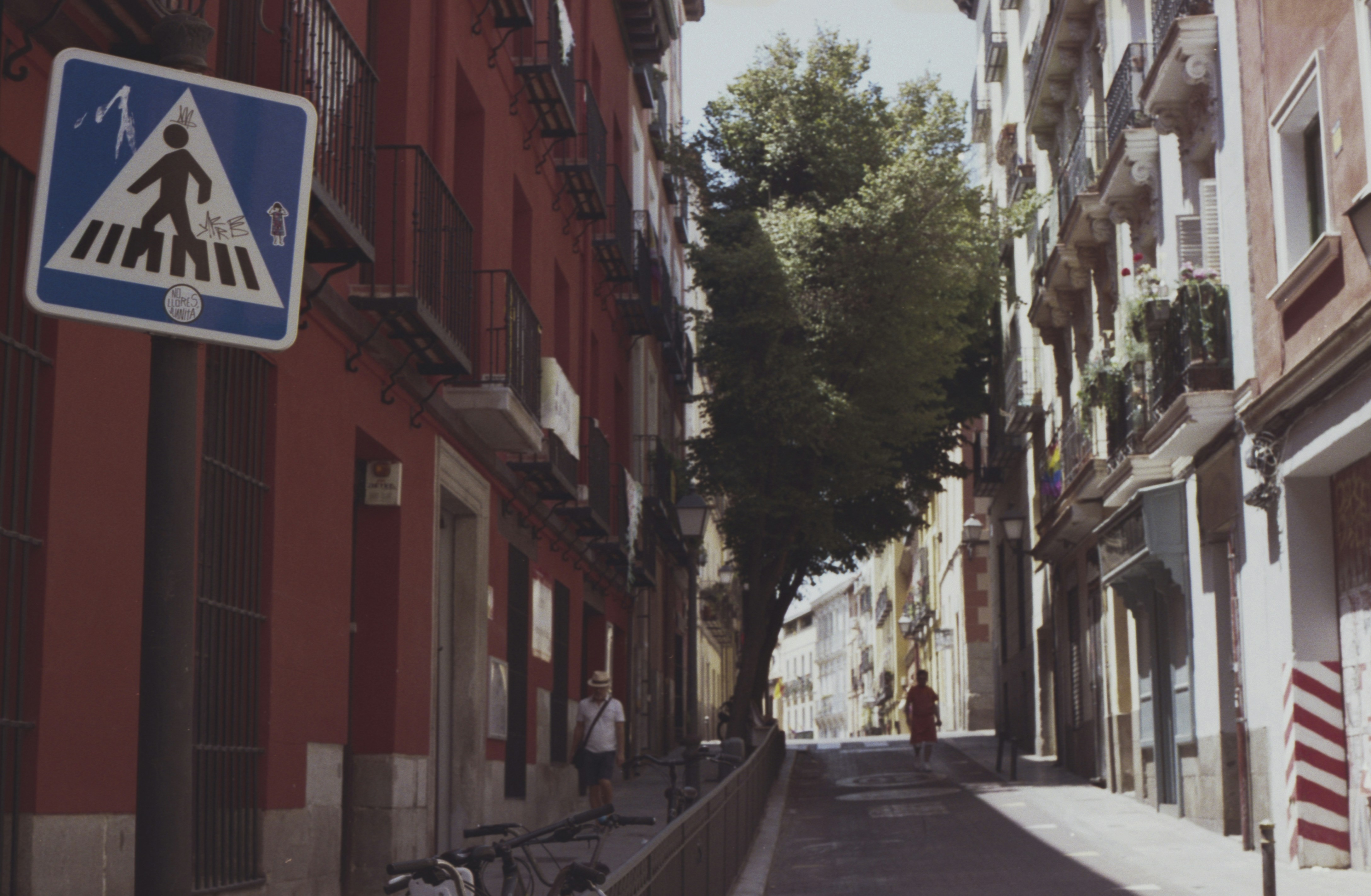 Pedestrian crossing sign on a narrow street.