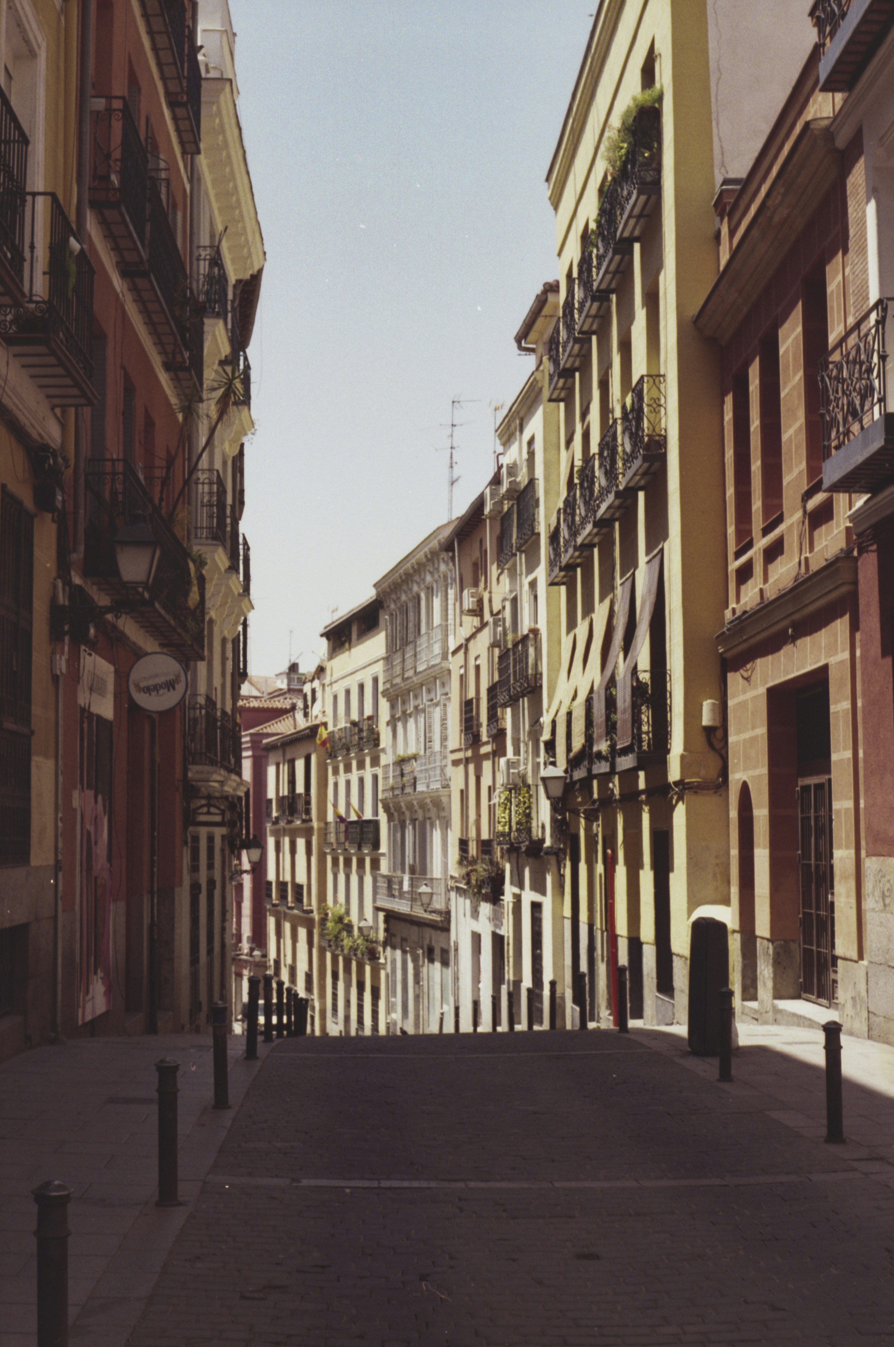 Narrow street lined with old buildings in sunlight