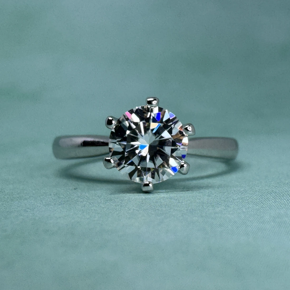 Profile view of a knife-edge solitaire ring on a pale backdrop