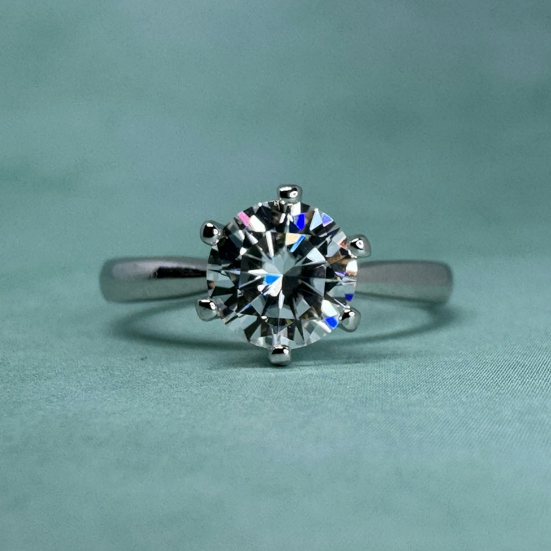 Profile view of a knife-edge solitaire ring on a pale backdrop