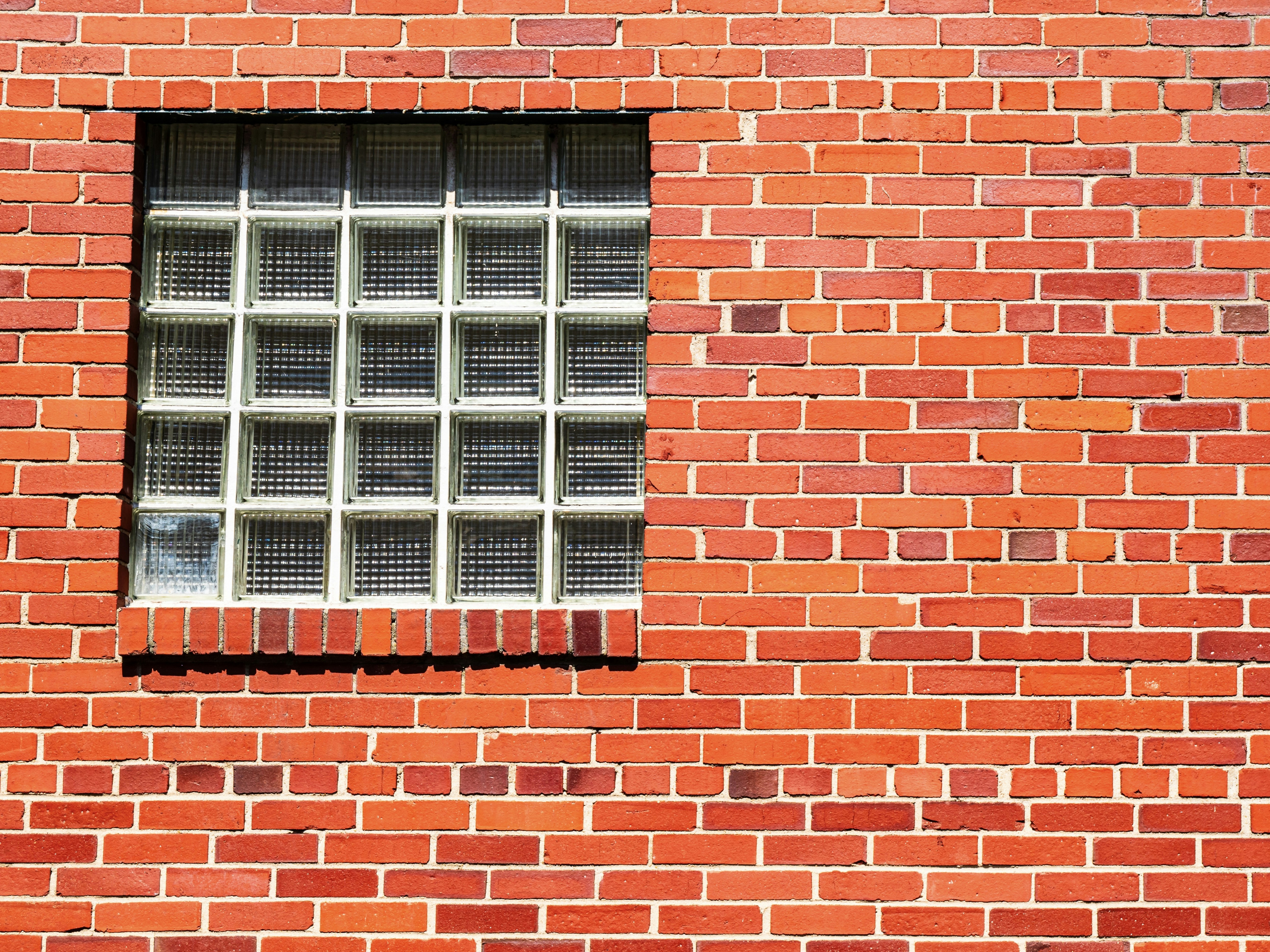 Red brick wall with a glass block window
