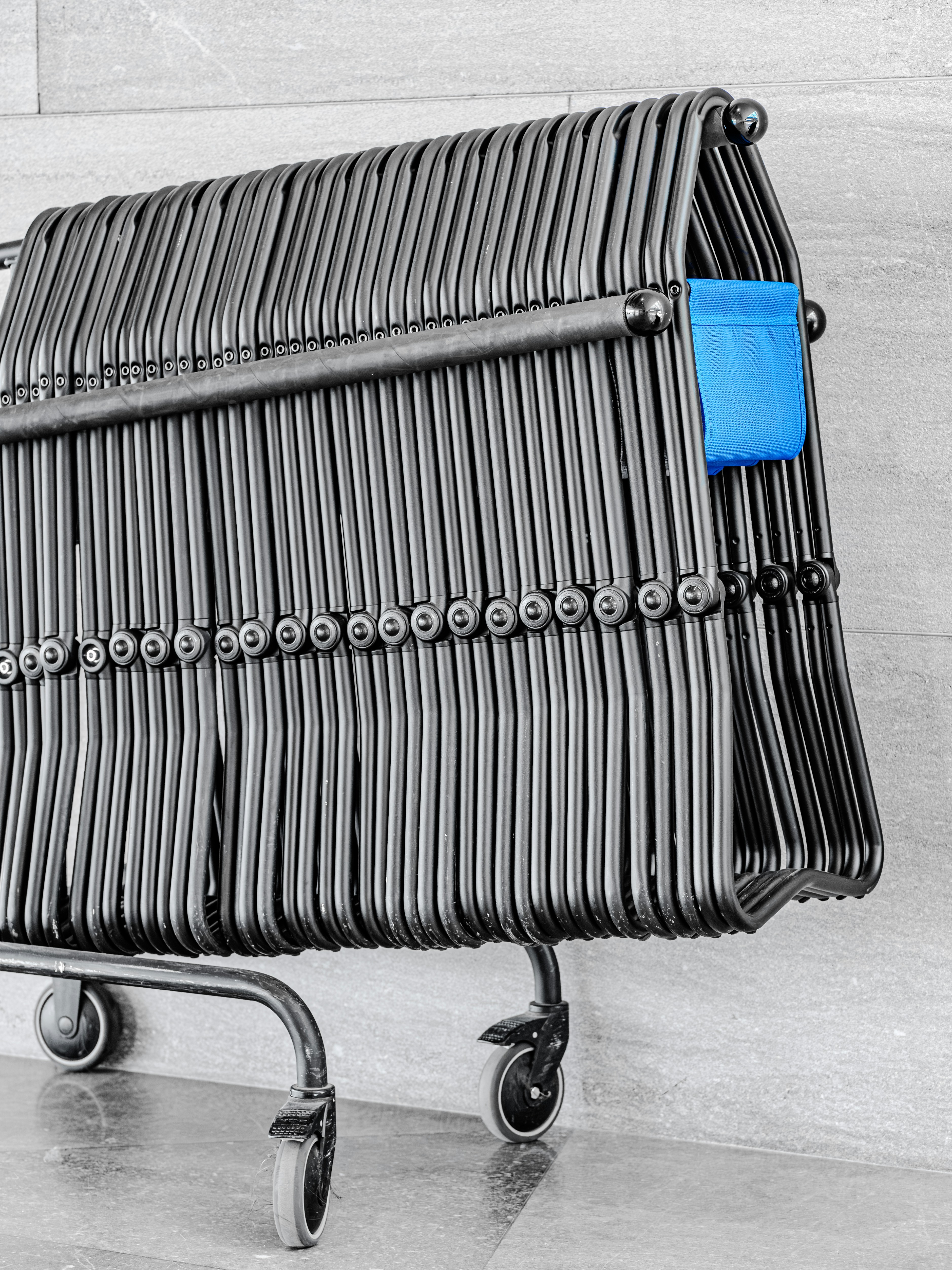 A metal shopping cart with a blue pouch