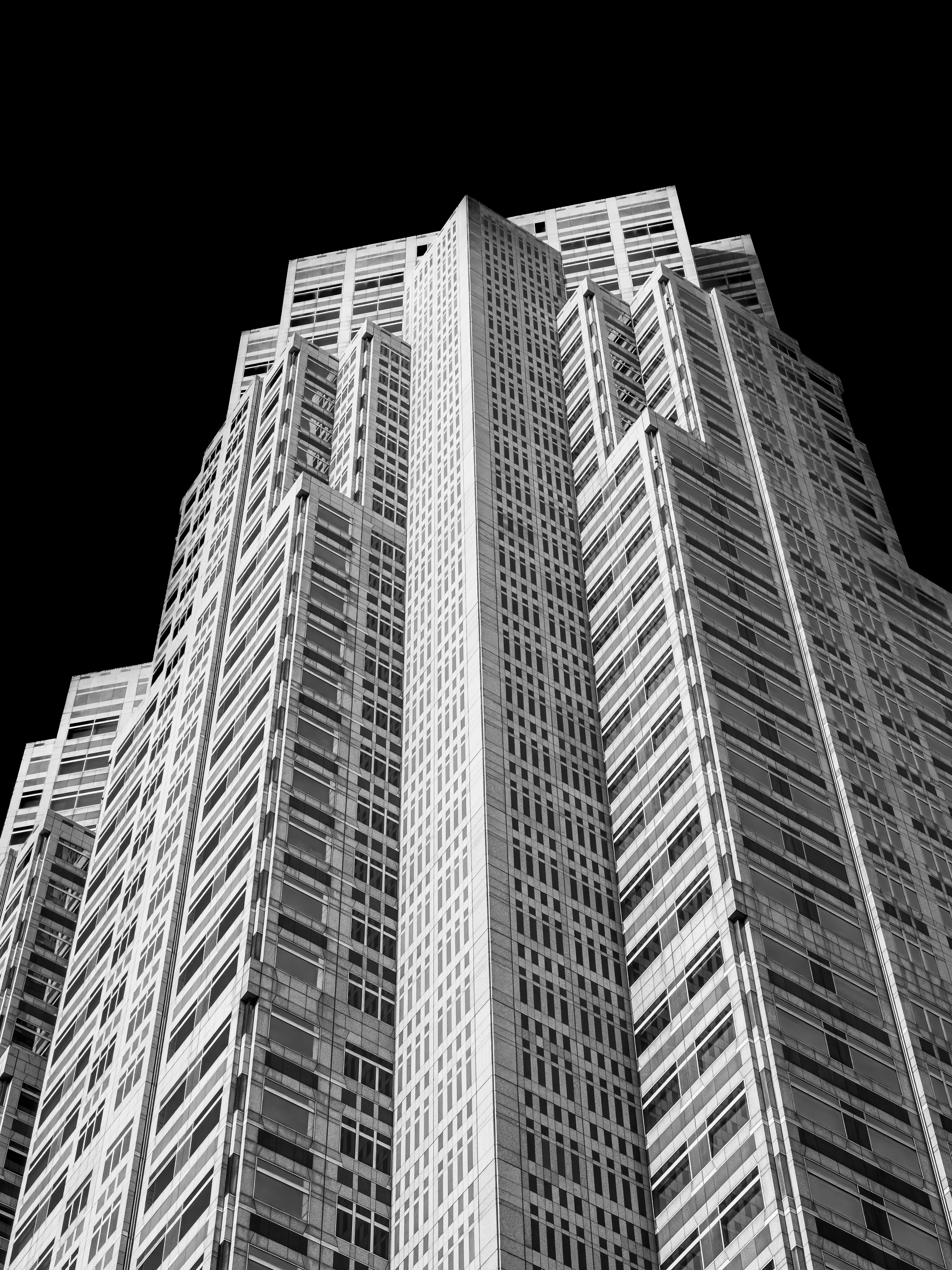 A tall skyscraper viewed from below against a black sky