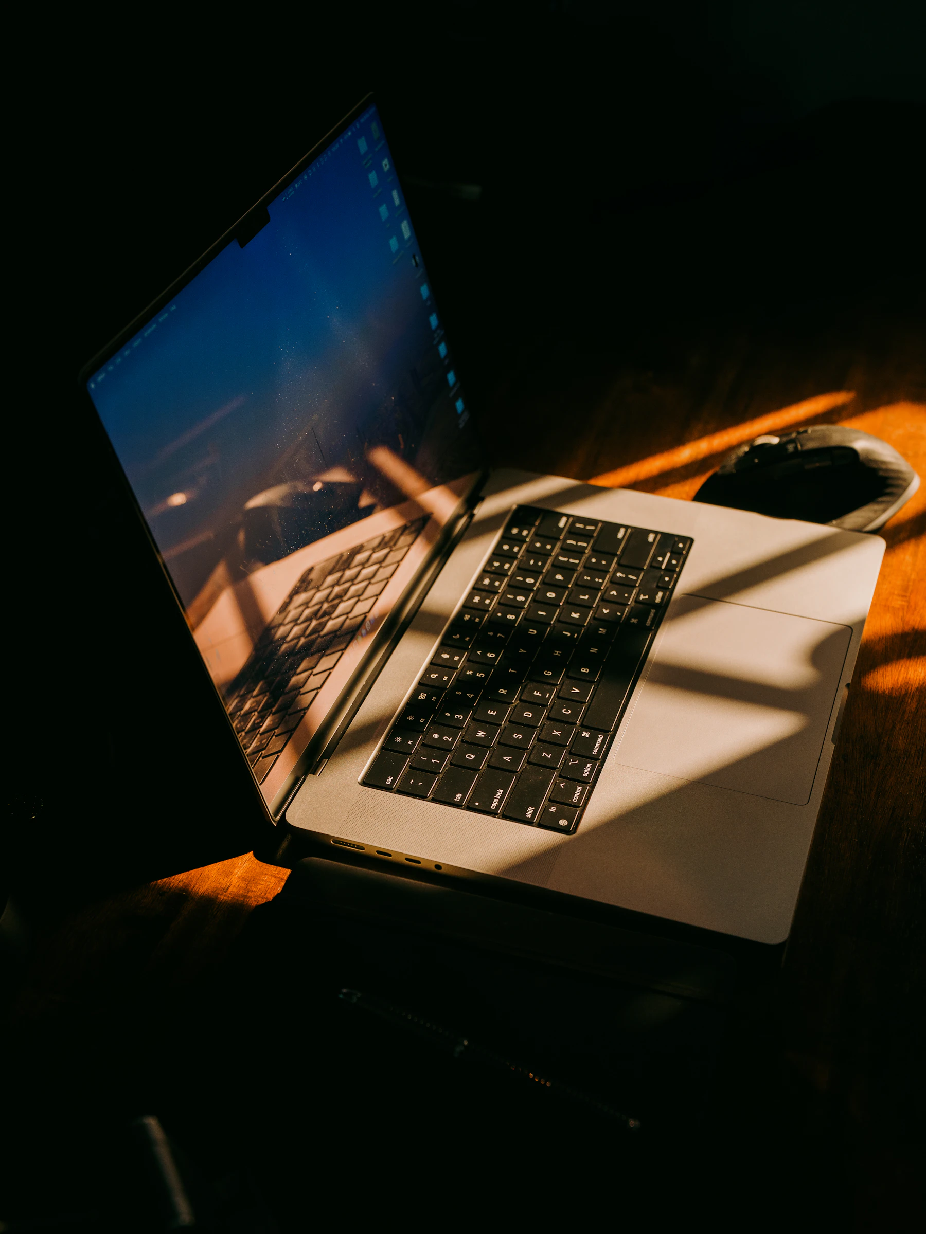 A laptop on a desk in early morning light
