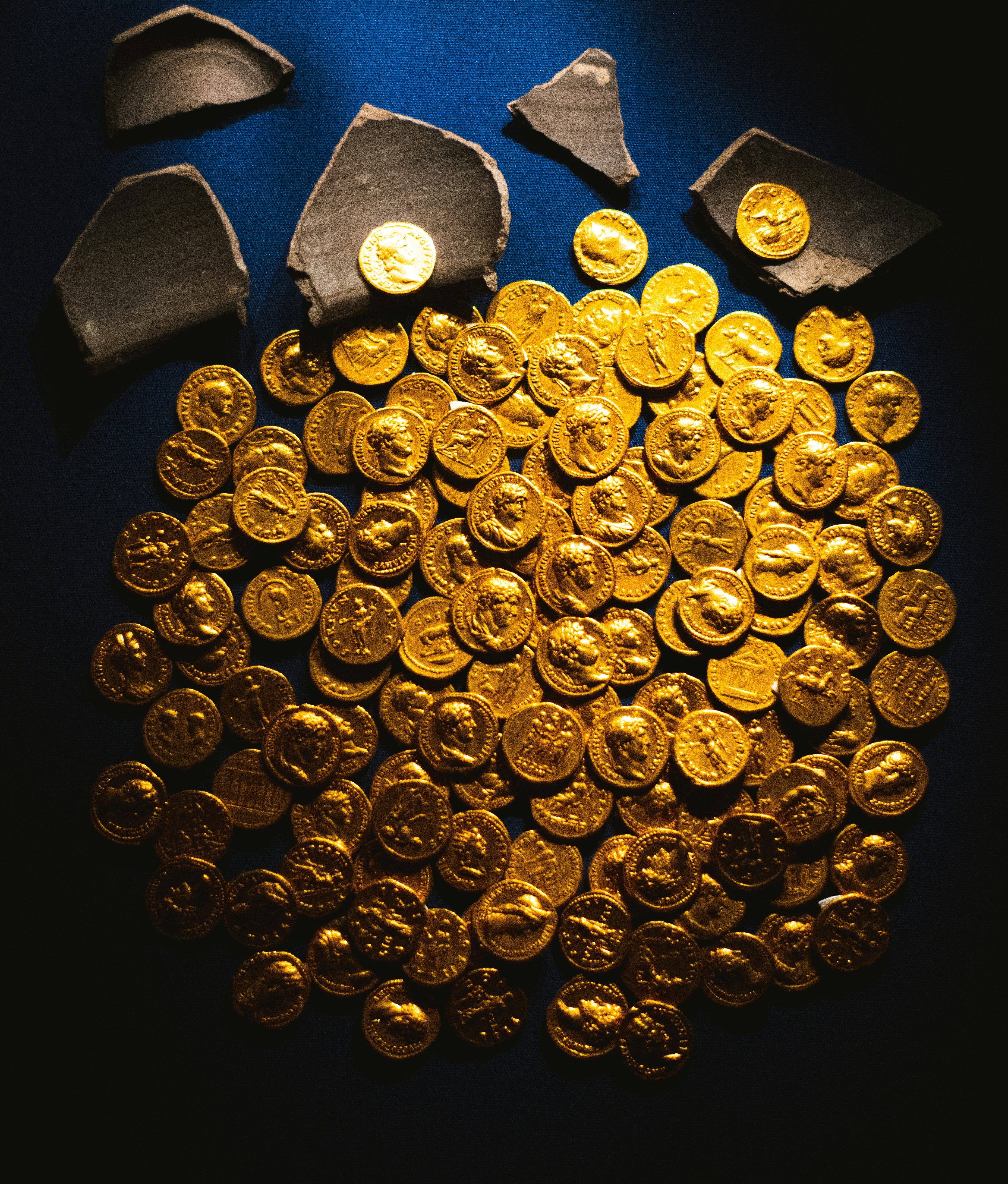 A pile of ancient gold coins with pottery shards.