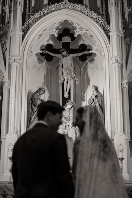 Couple at altar with crucifix and statues