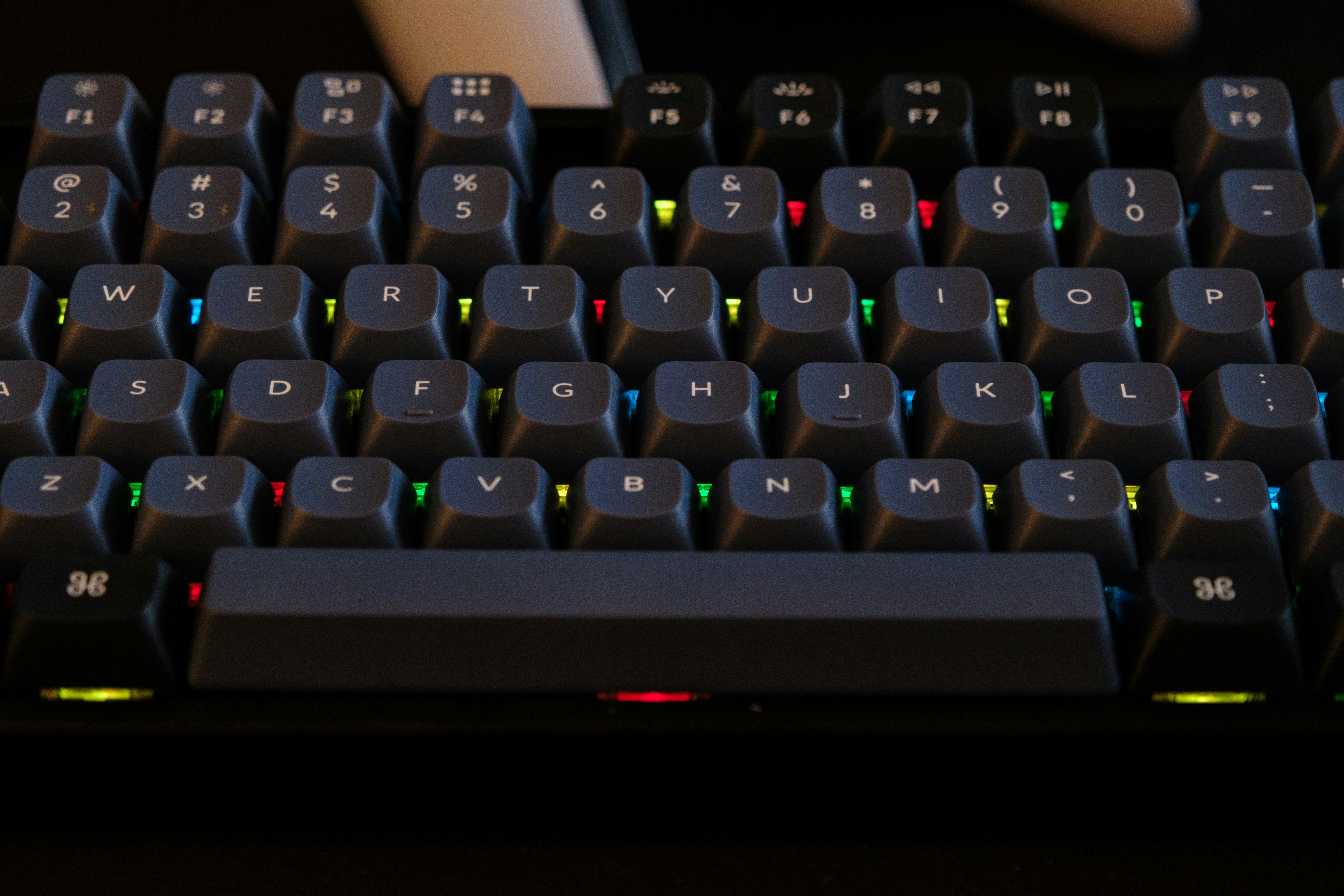 Close-up of a backlit mechanical keyboard with colorful keys.