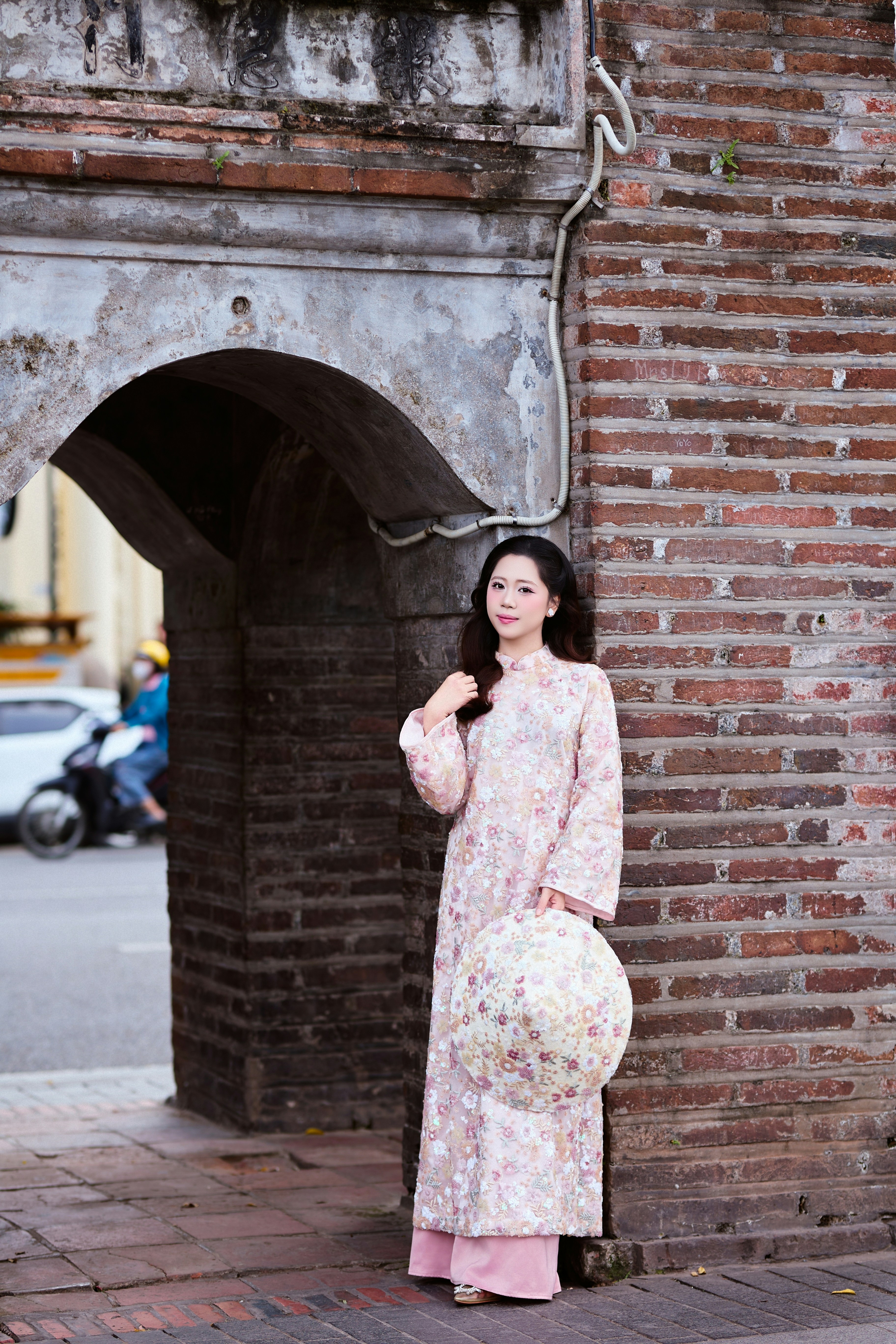 Woman in traditional dress holding a conical hat