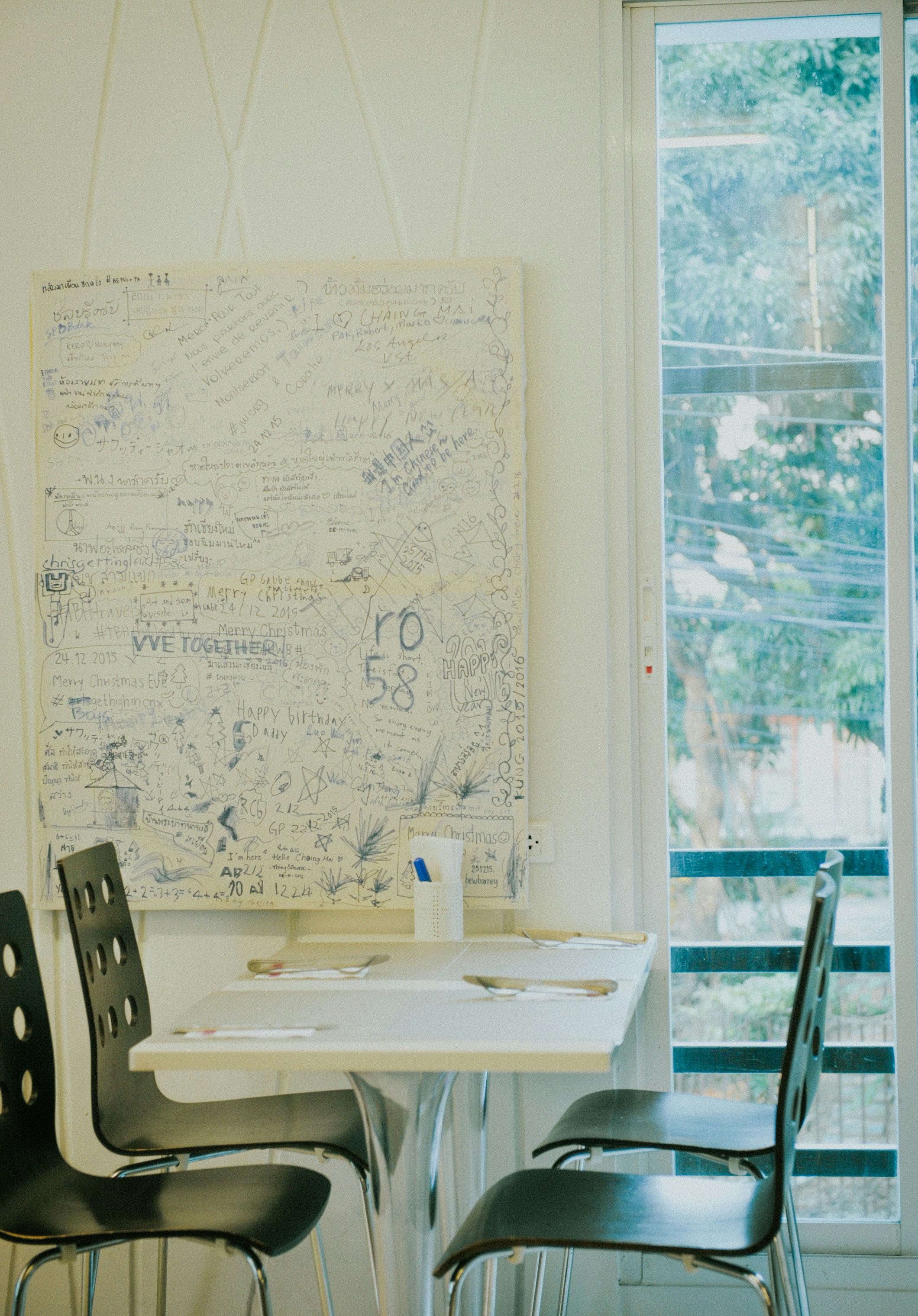 Table with chairs and a wall covered in writing.