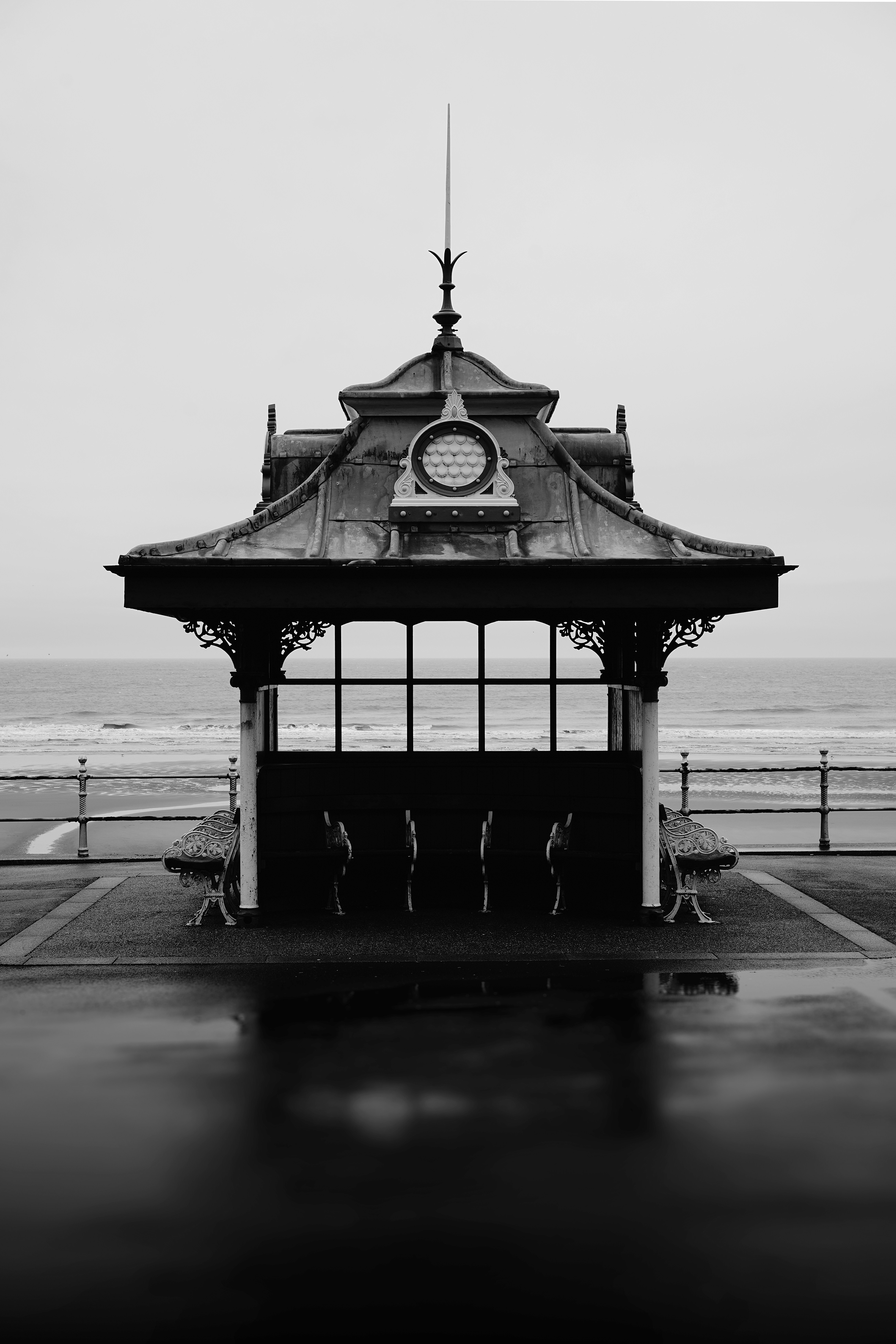 Ornate pavilion on a wet promenade by the sea