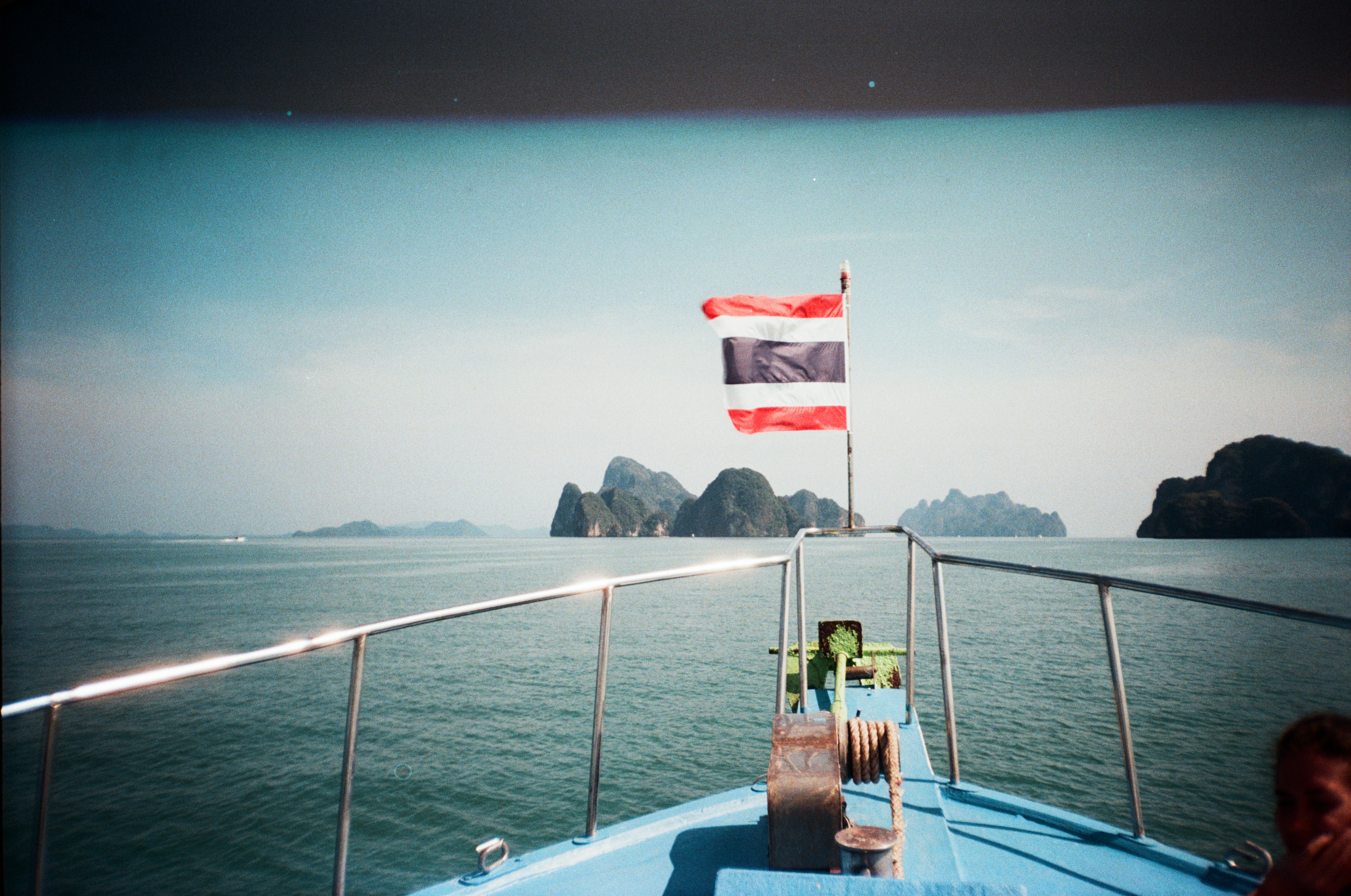 Thai flag on boat sailing towards islands