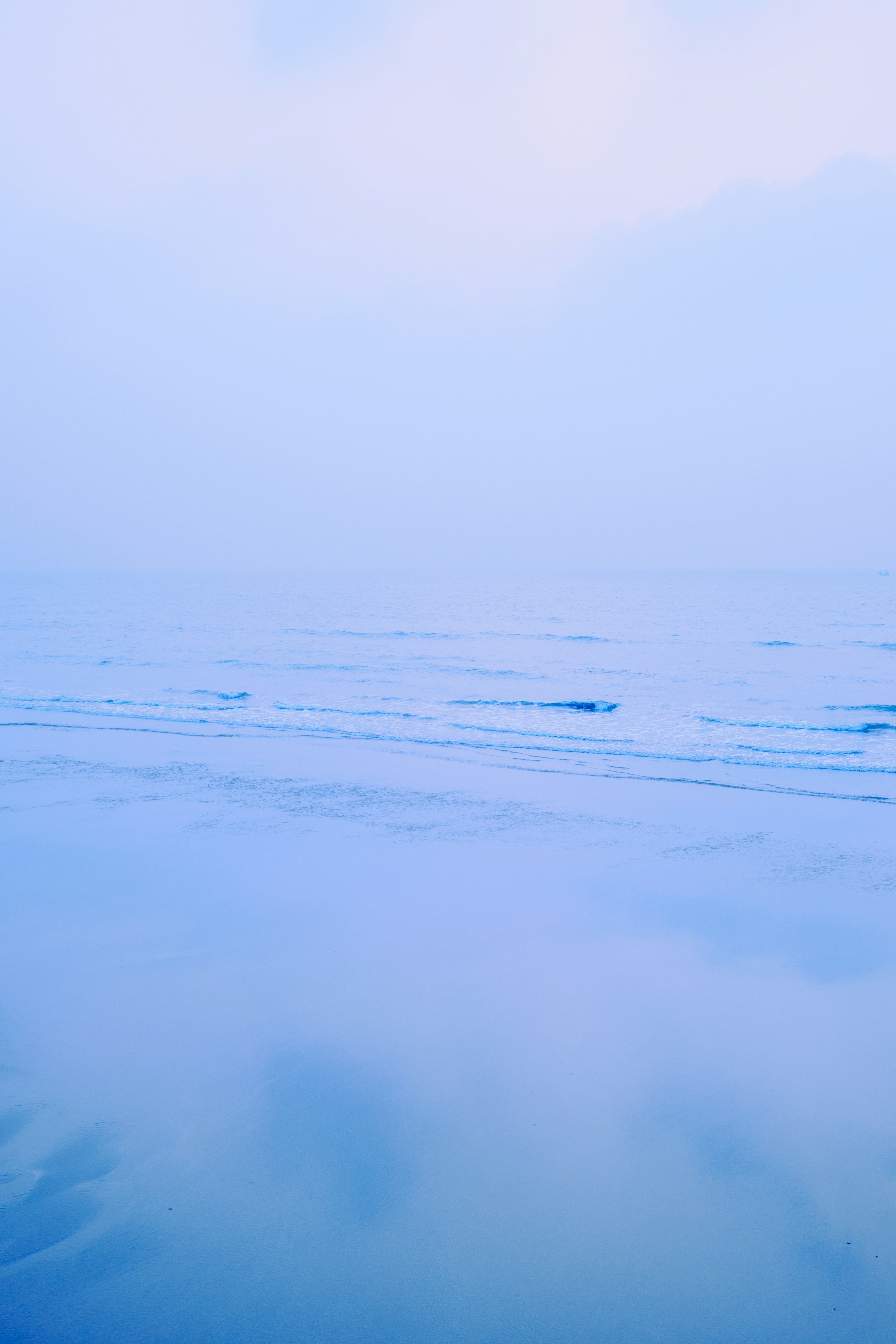 Ondas calmas do oceano sob um céu enevoado
