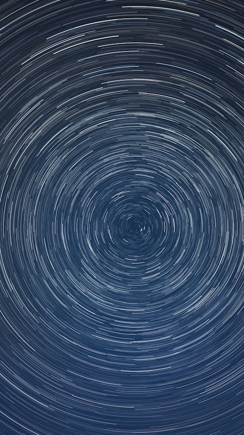 Circular star trails against a dark blue sky