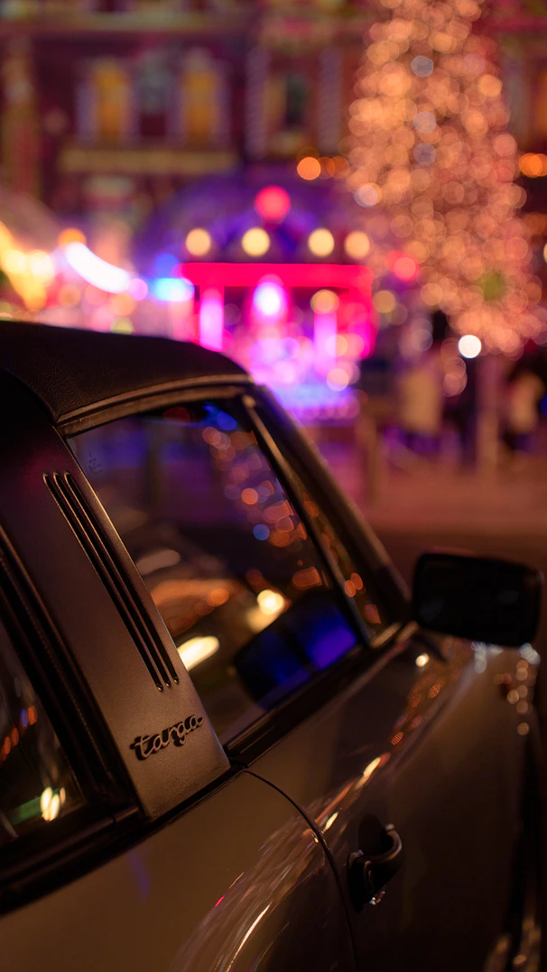 Classic car parked at a festive night market