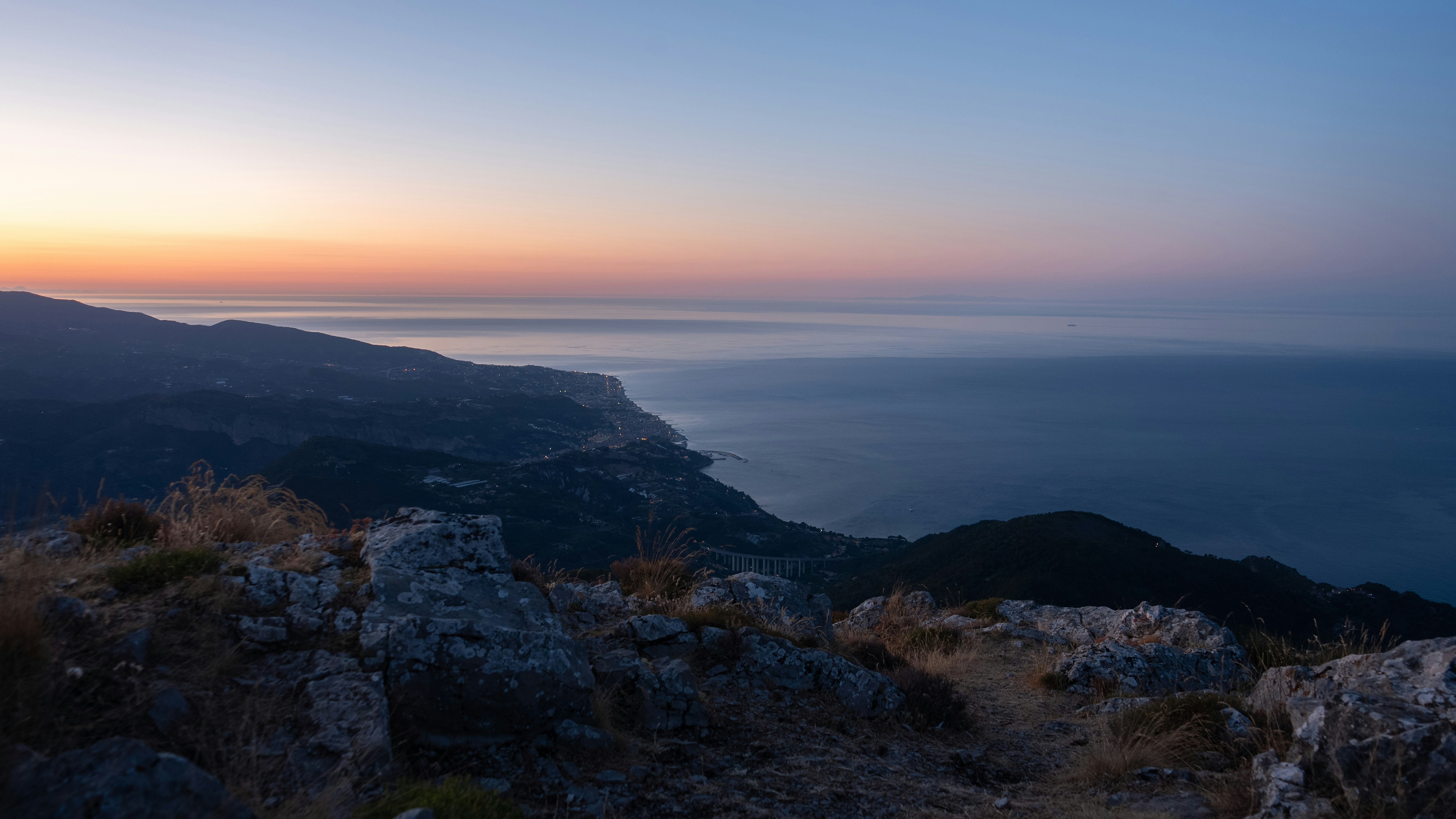 Sunrise over a calm ocean from a mountaintop