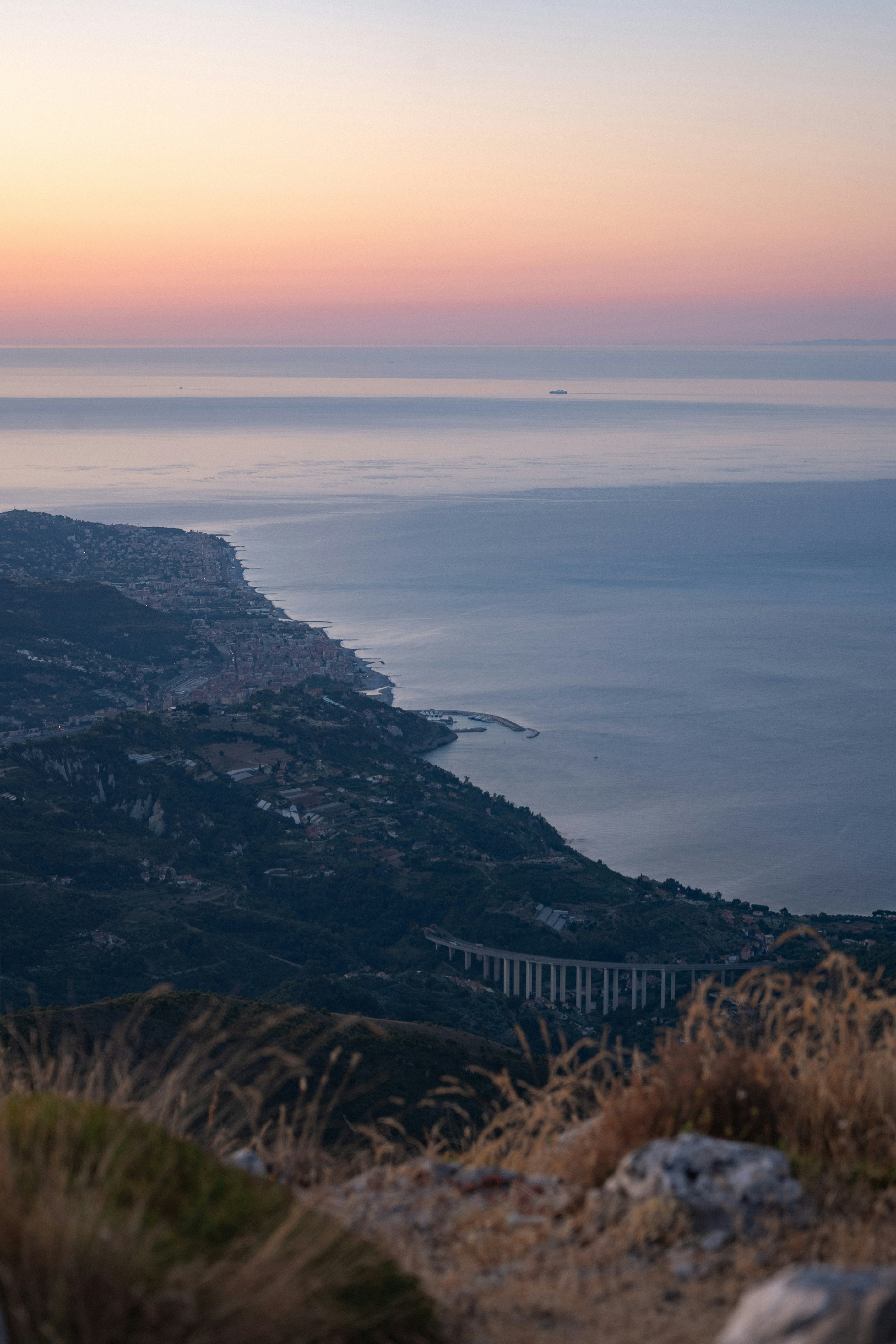 Coastal town with bridge overlooking the ocean at sunset