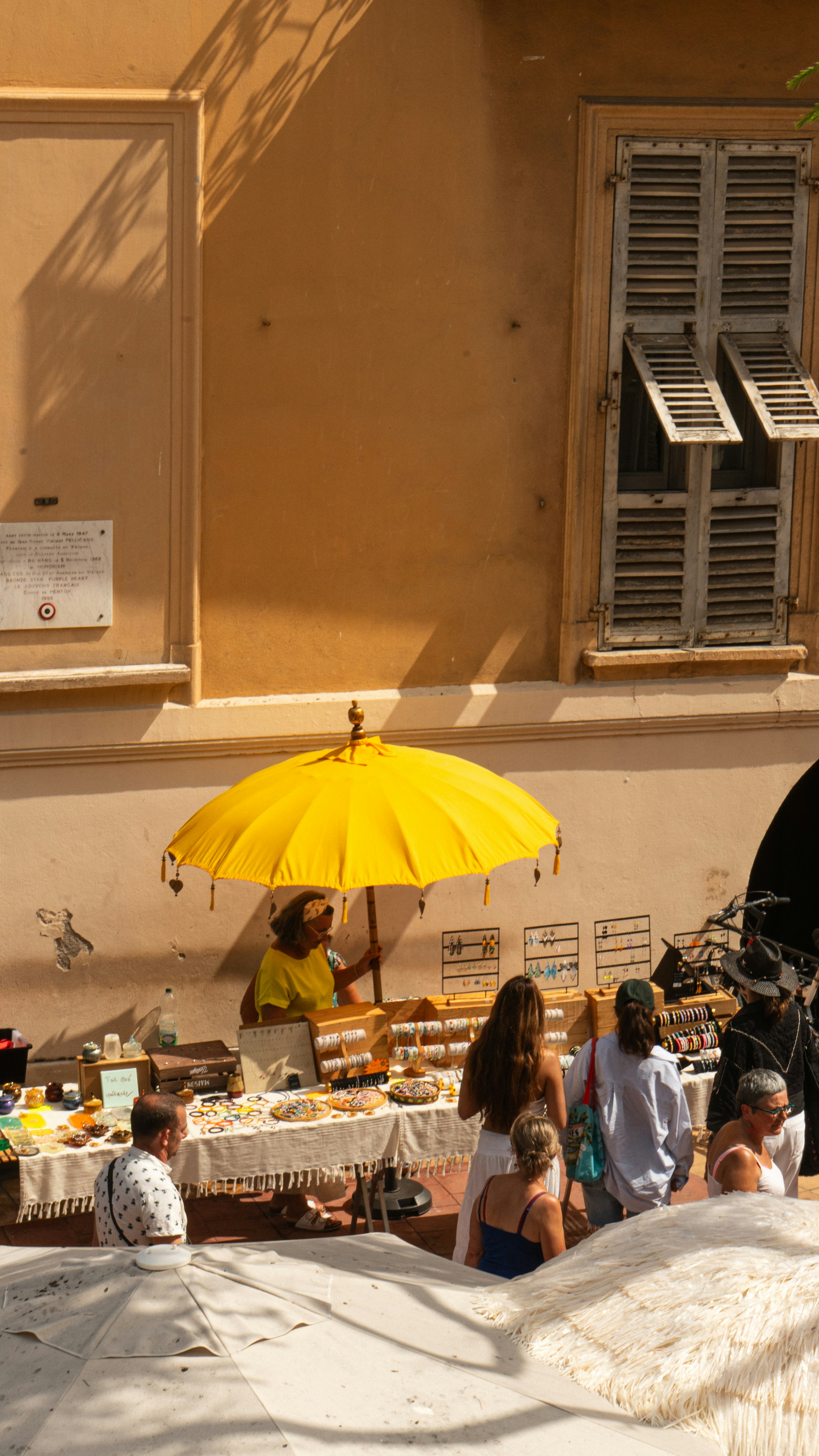People browsing jewelry at an outdoor market stall.