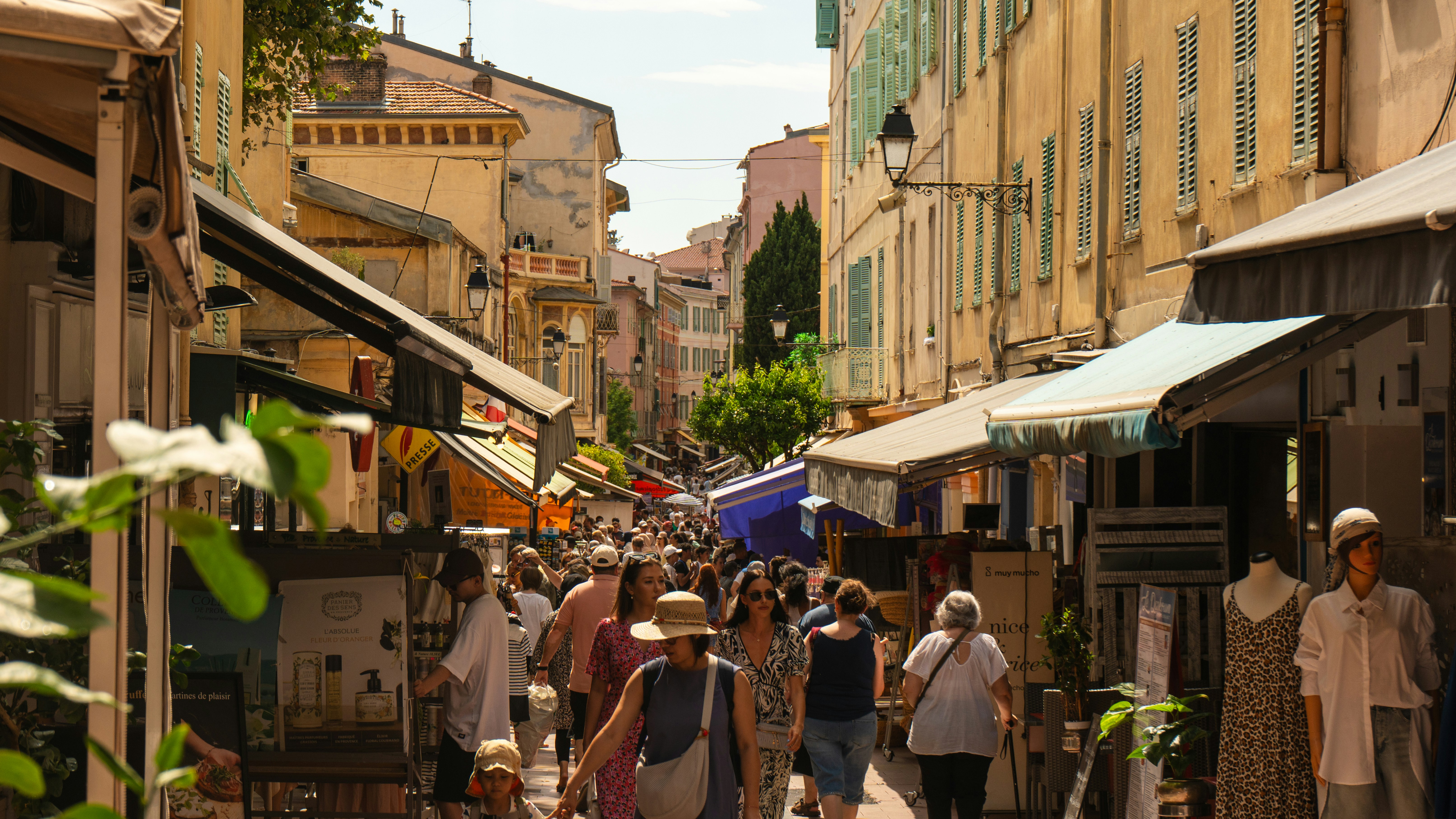Crowded european street market with shops and people.