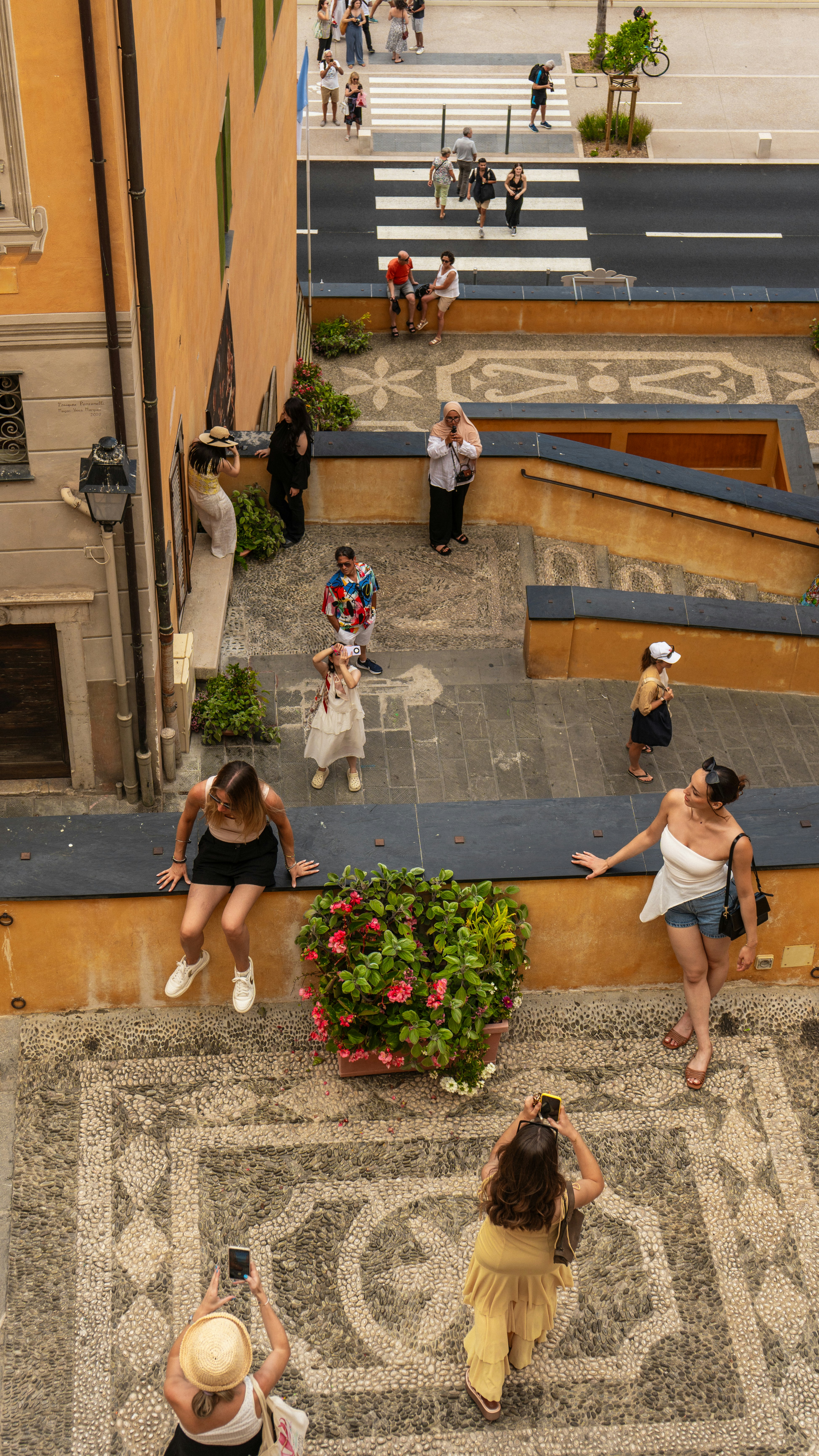 People taking photos on a sunny day in a town.