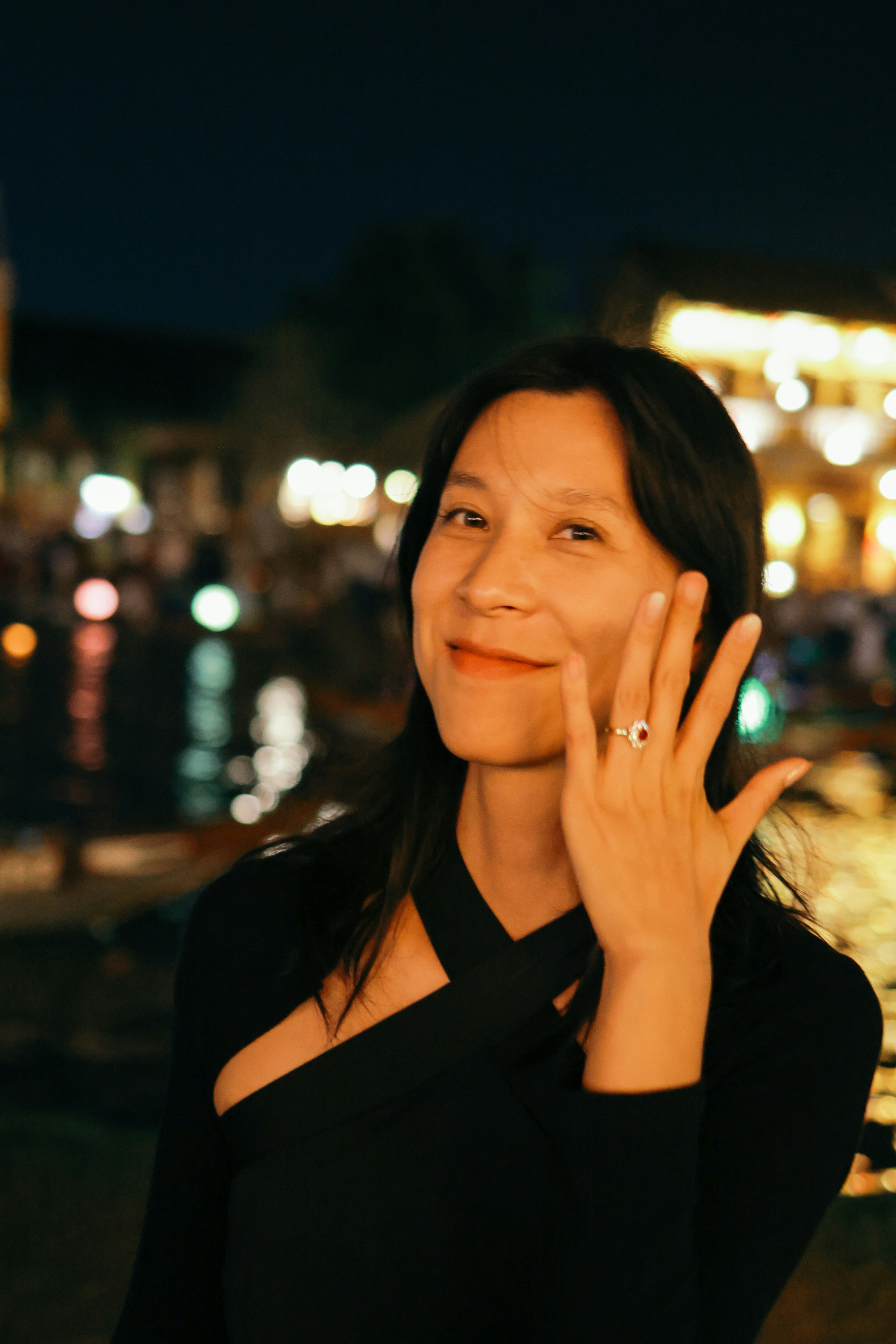 Une femme montre une bague de fiançailles la nuit