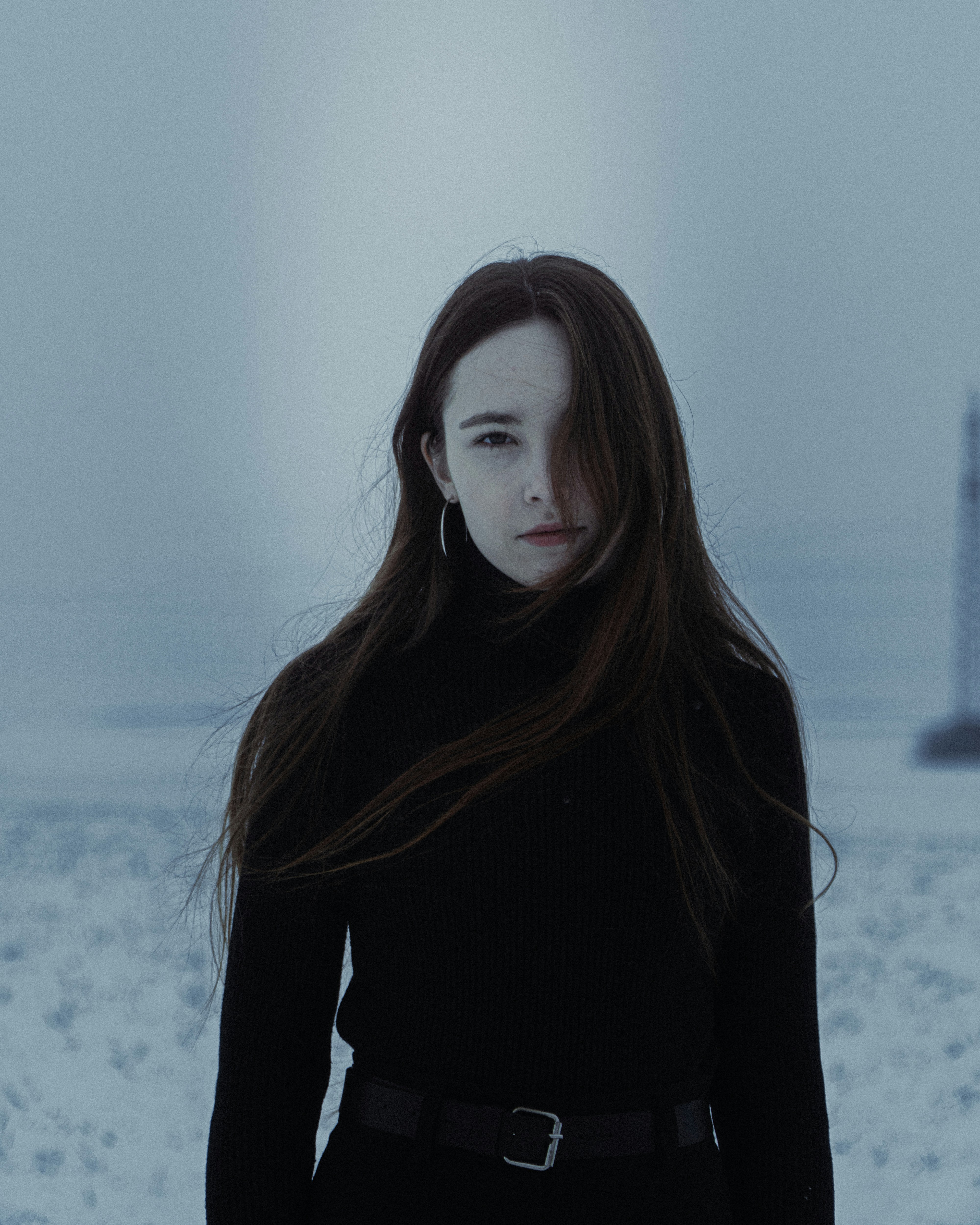 Young woman in black turtleneck standing in snow