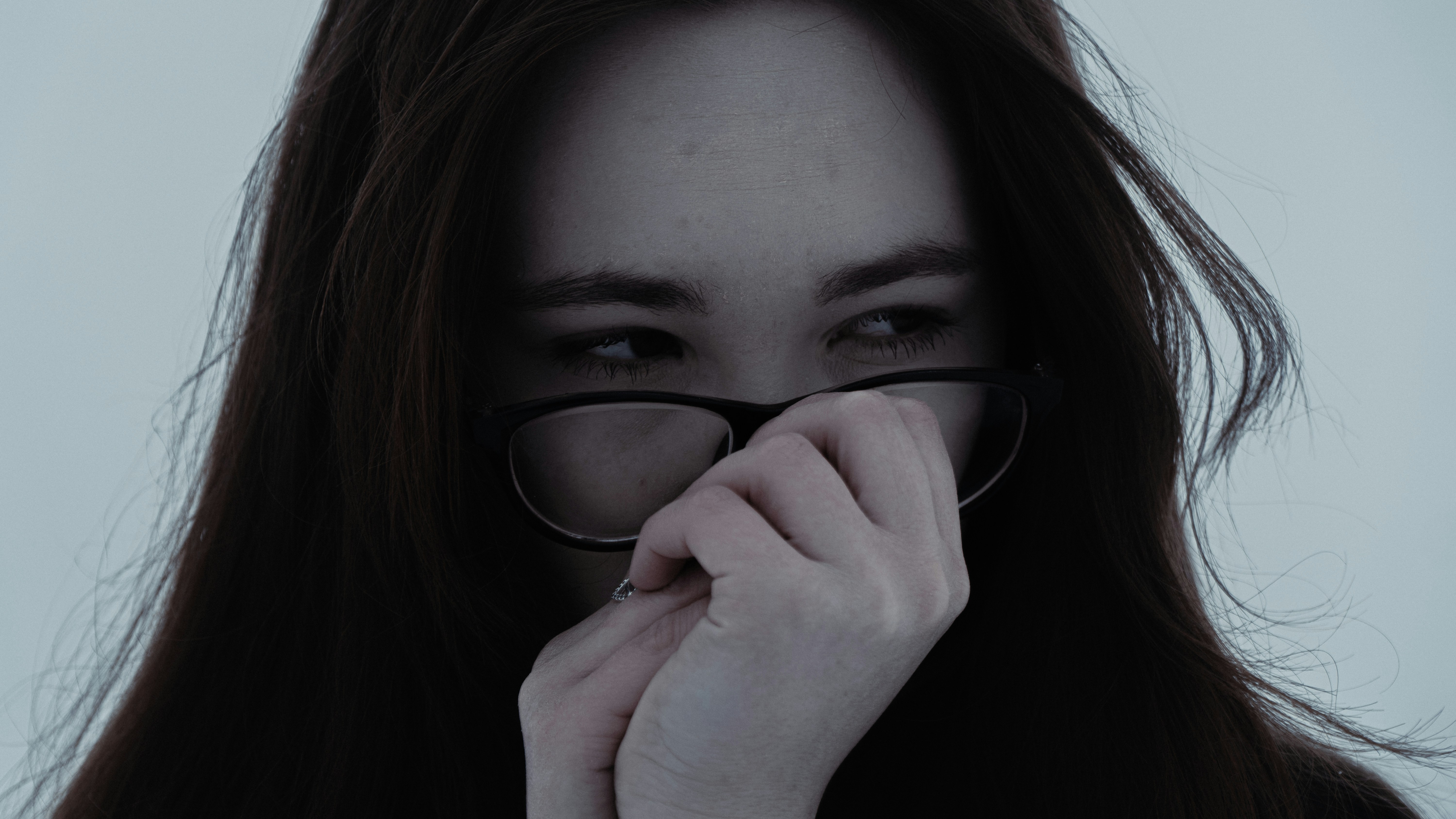 Young woman with glasses looking away shyly